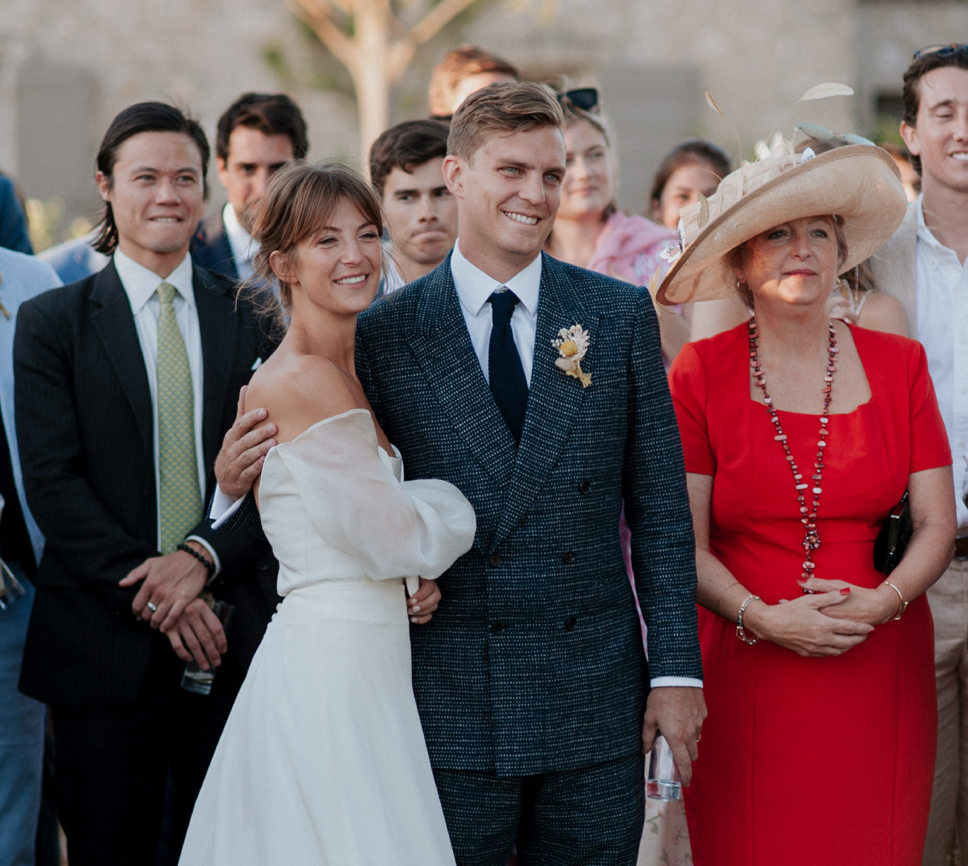 Guest, bride and groom at wedding smiling. Groom wears Casely-Hayford double breast blazer in blue.