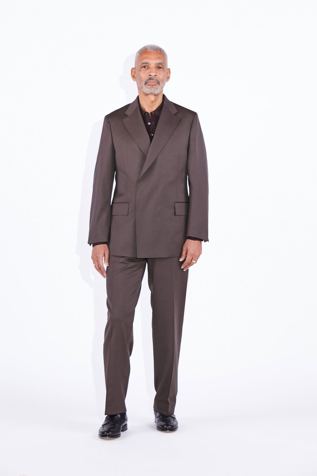 Model wears Casely-Hayford Ofili Brown Concealed Button Wool Suit. 