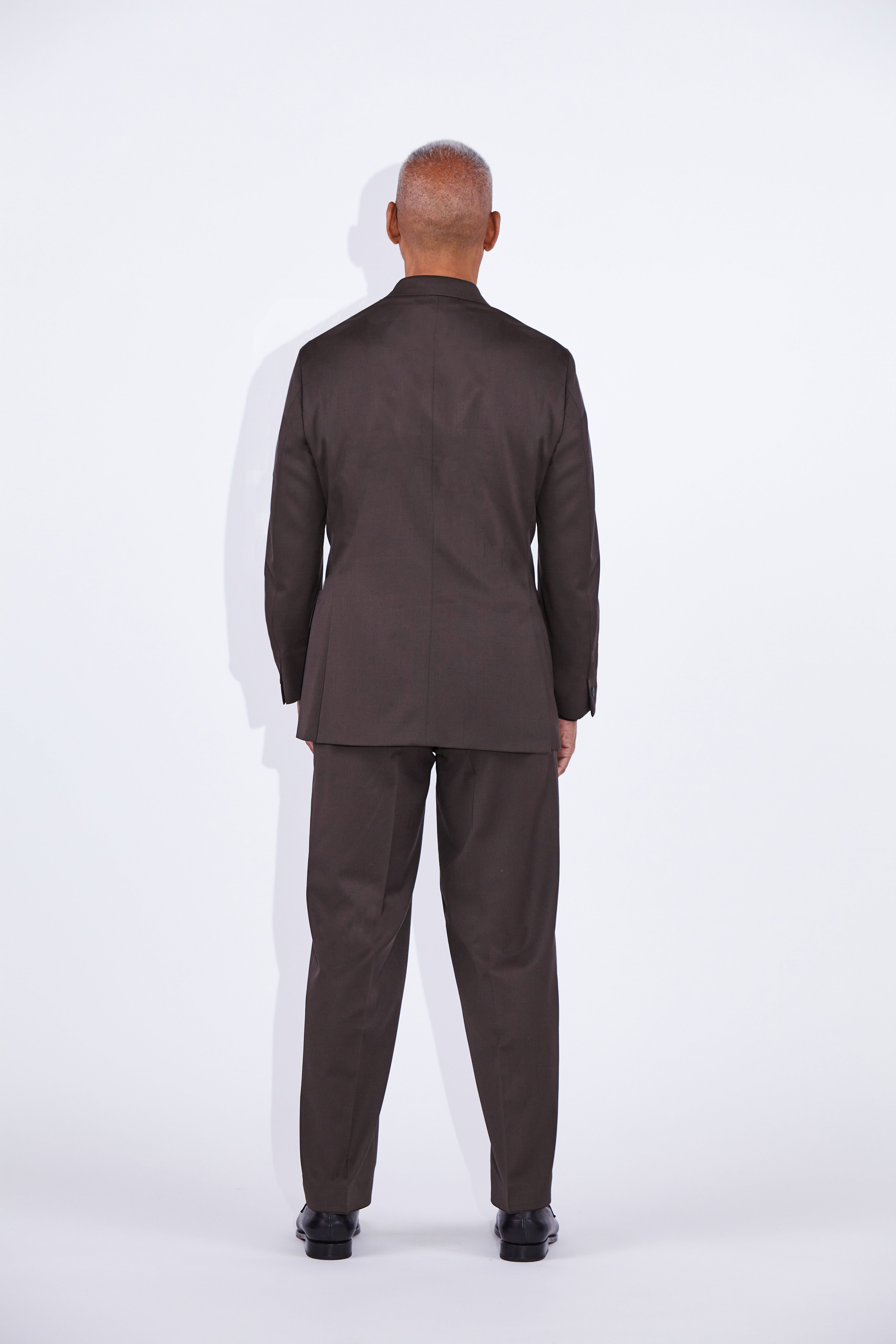 Model wears Casely-Hayford Ofili Brown Concealed Button Wool Suit. 