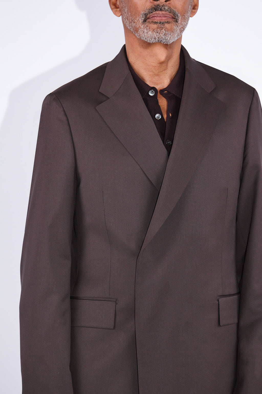 Model wears Casely-Hayford Ofili Brown Concealed Button Wool Suit. 