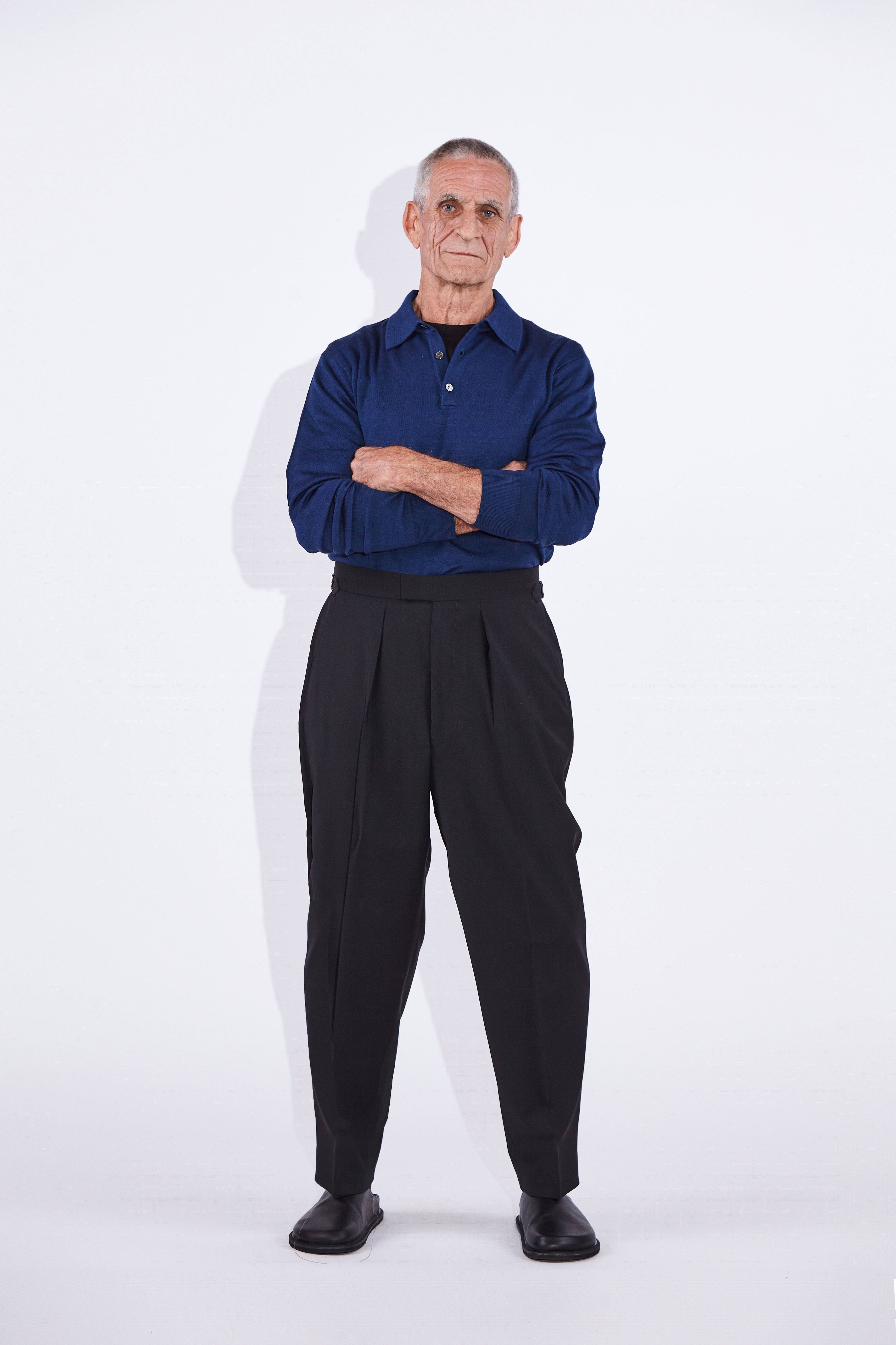 Model wears Casely-Hayford Ezra Black Fresco Relaxed Tapered Leg Wool Trousers. 