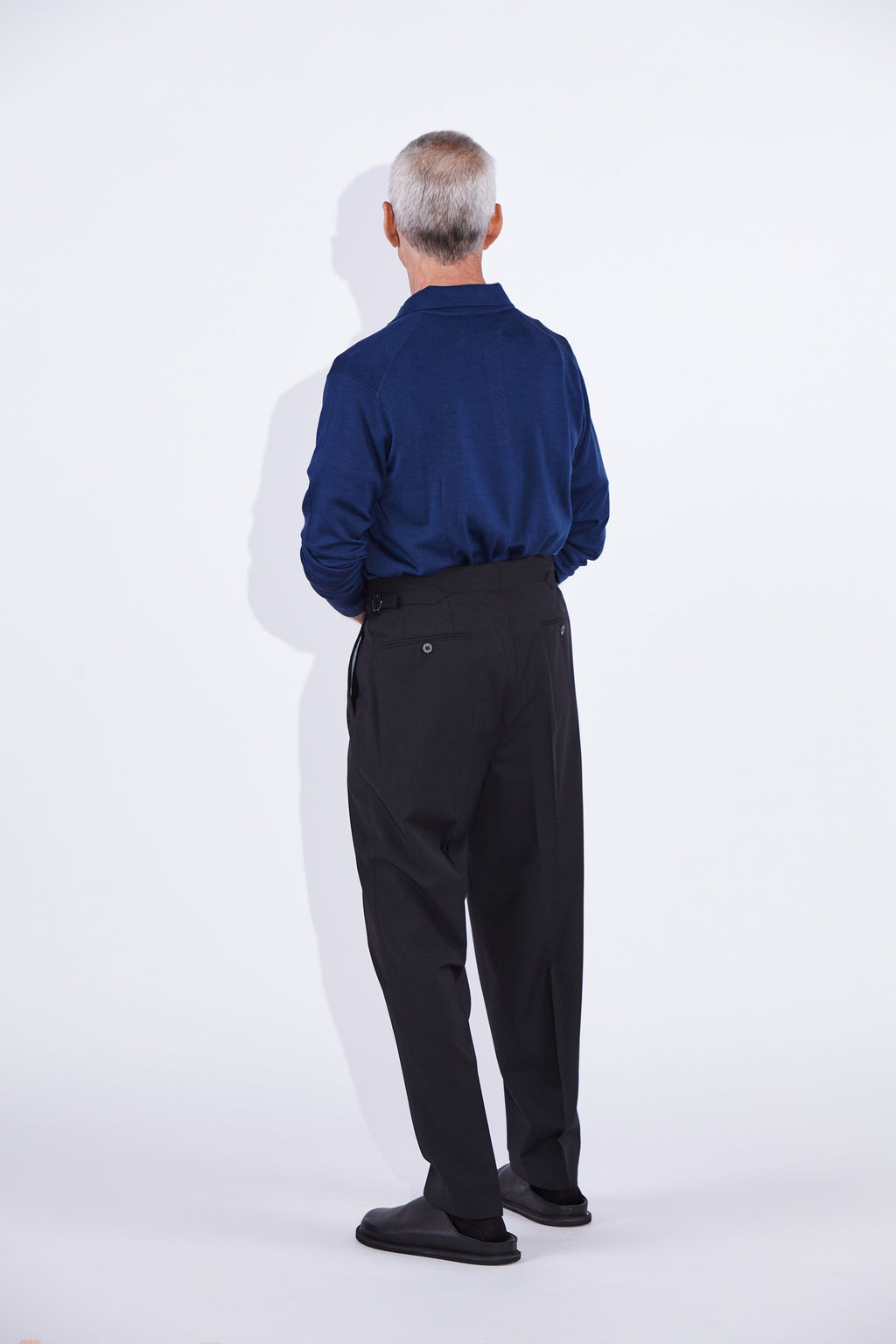 Model wears Casely-Hayford Ezra Black Fresco Relaxed Tapered Leg Wool Trousers. 