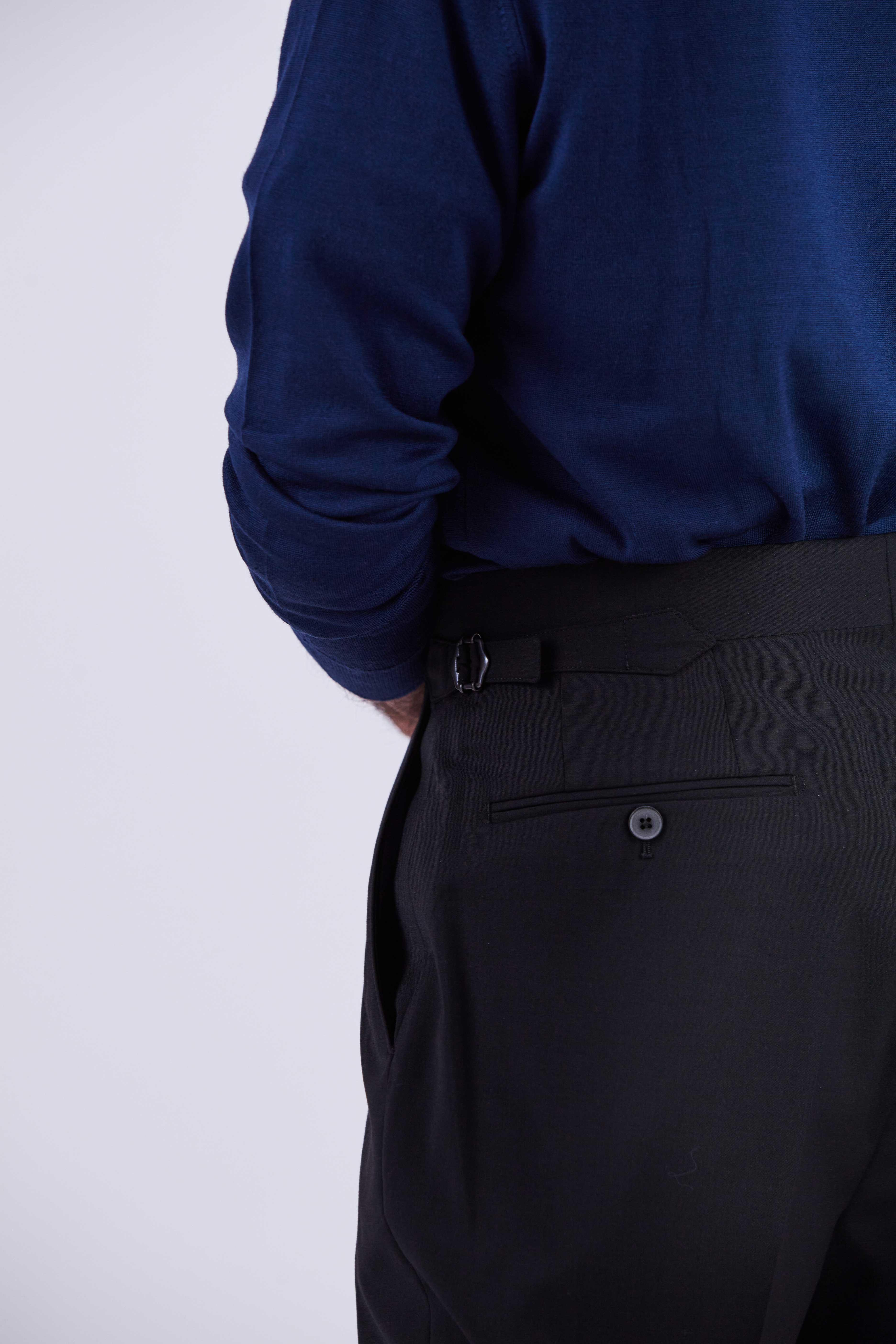 Model wears Casely-Hayford Ezra Black Fresco Relaxed Tapered Leg Wool Trousers. 