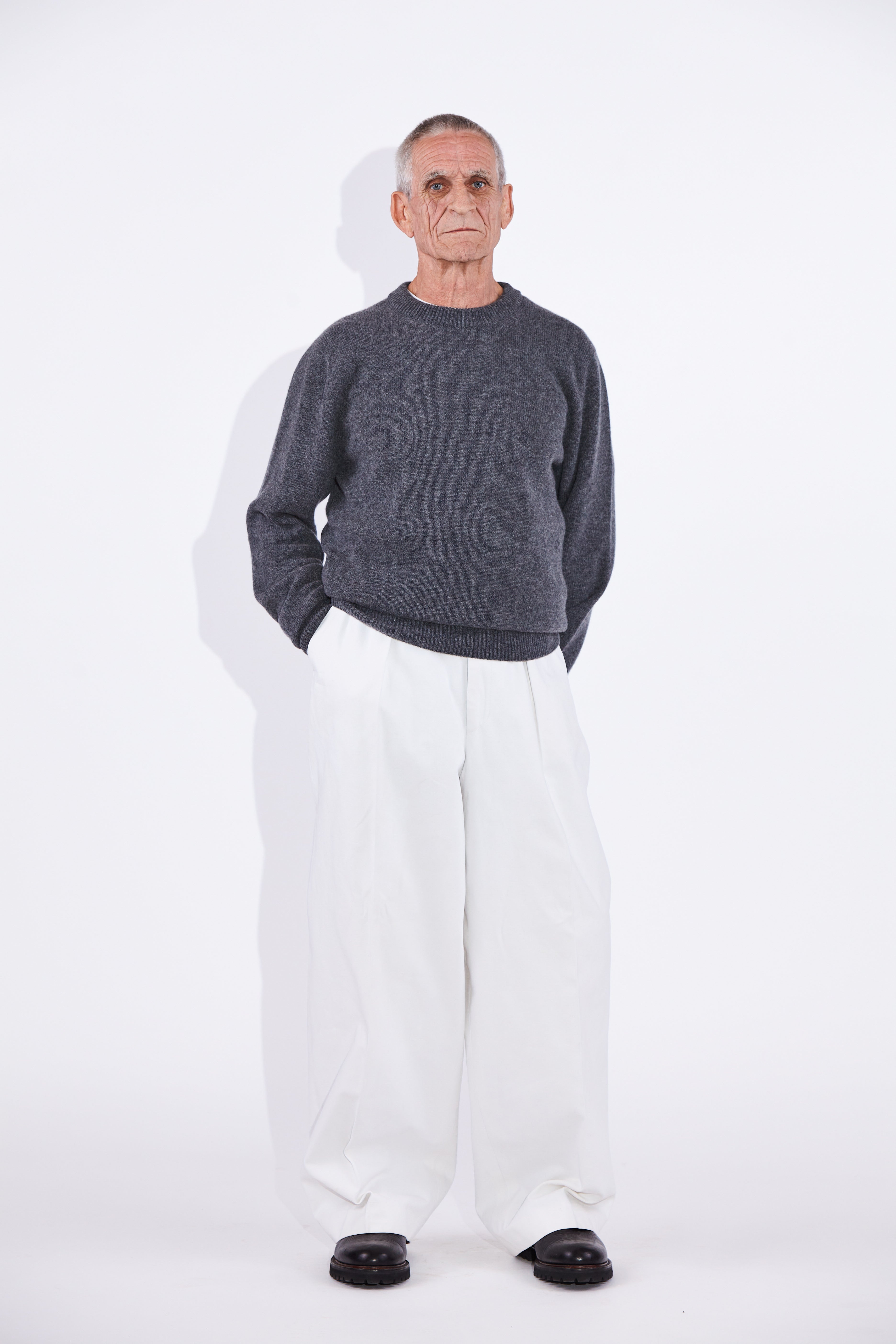 Model wears Casely-Hayford Rory Derby Grey Cashmere Crew Neck Knit.