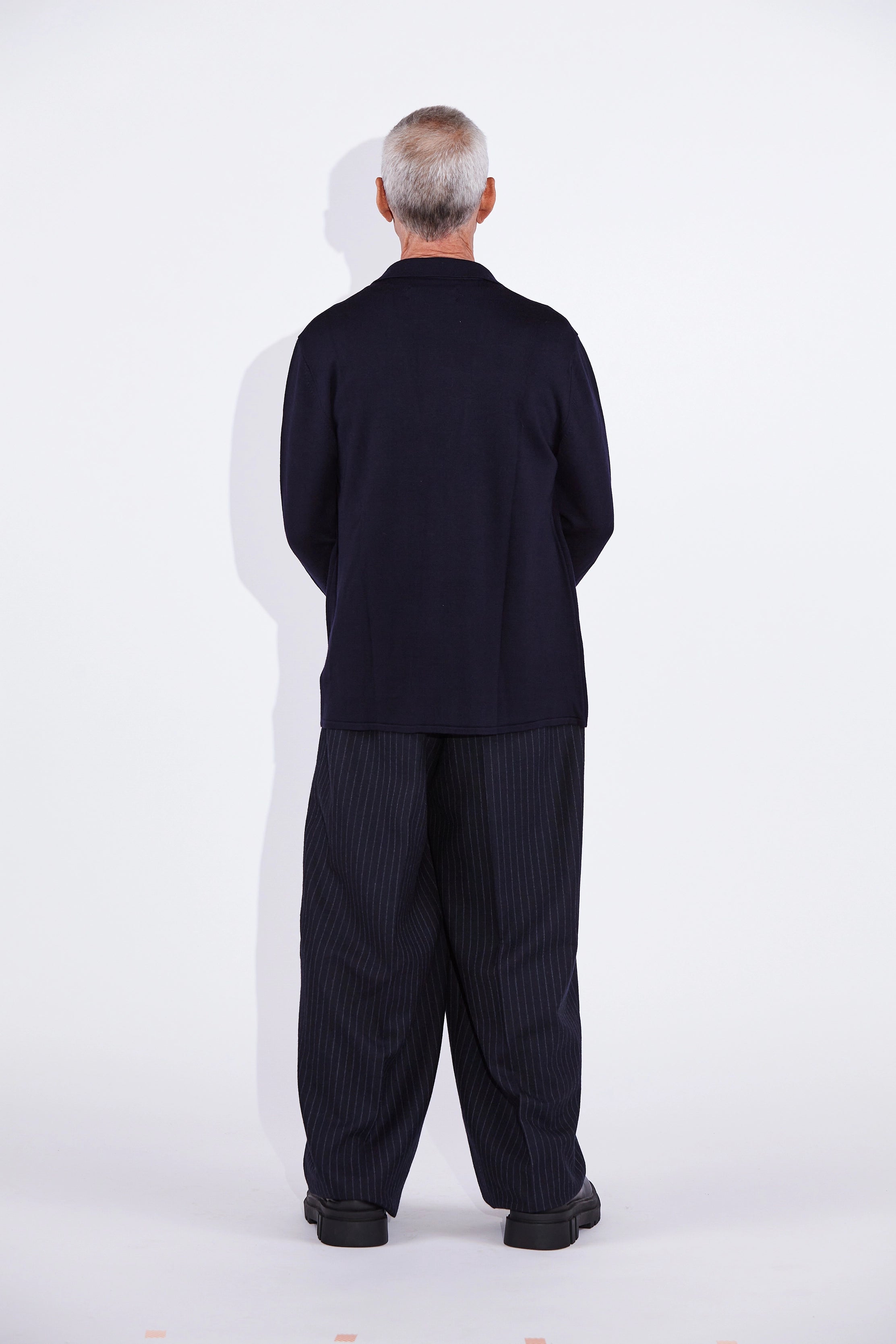 Model wears Casely-Hayford Cole Navy Knitted Notch Lapel Blazer.