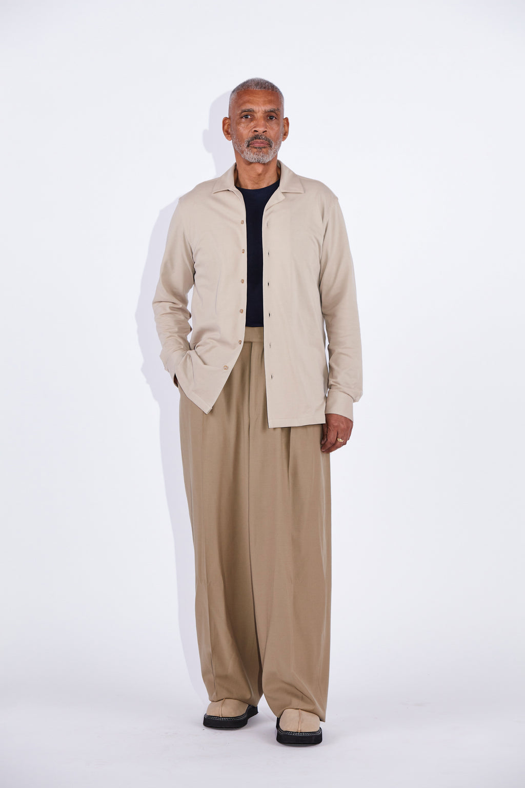 Model wears Casely-Hayford Jax shirt in beige. 