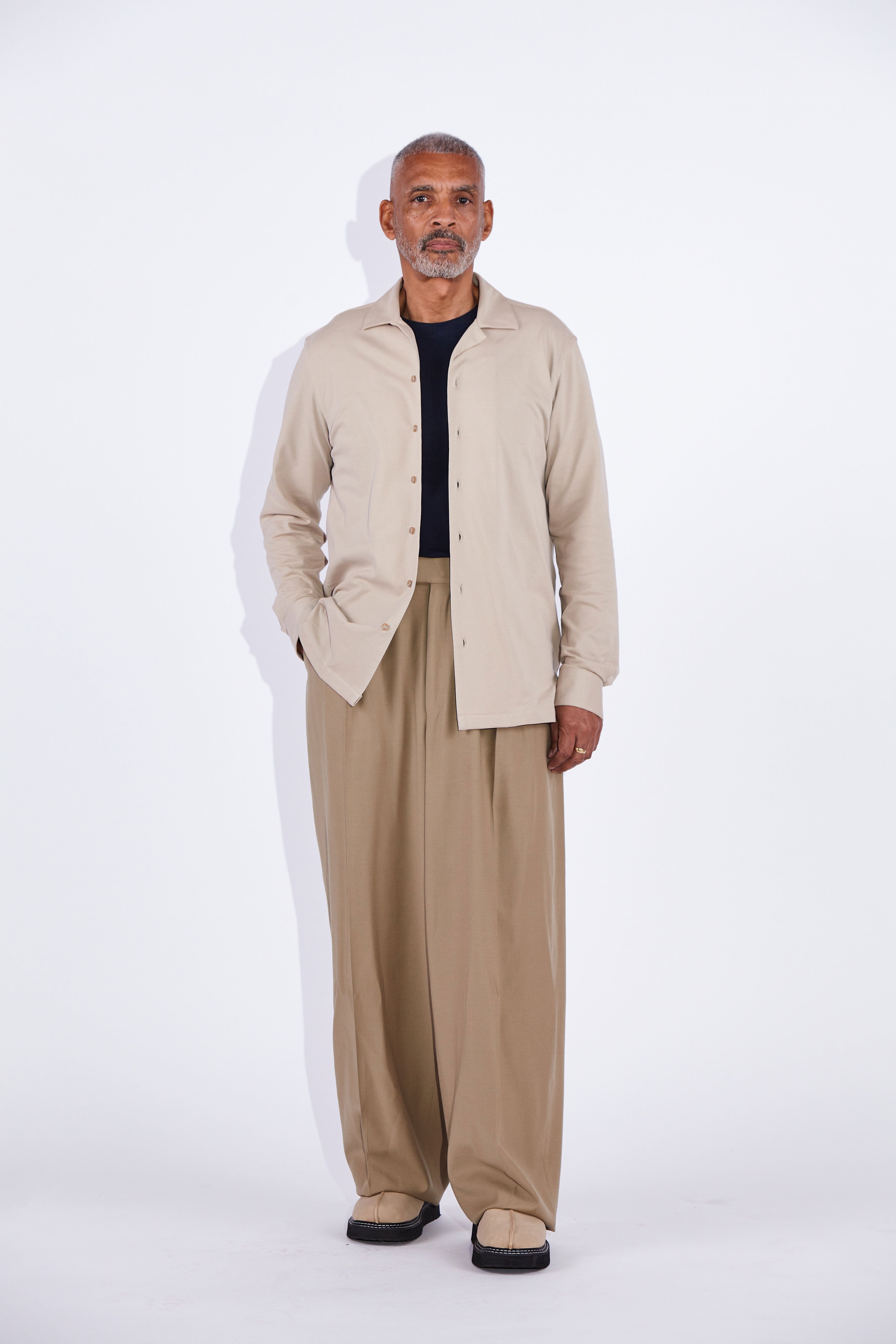 Model wears Casely-Hayford Jax shirt in beige. 