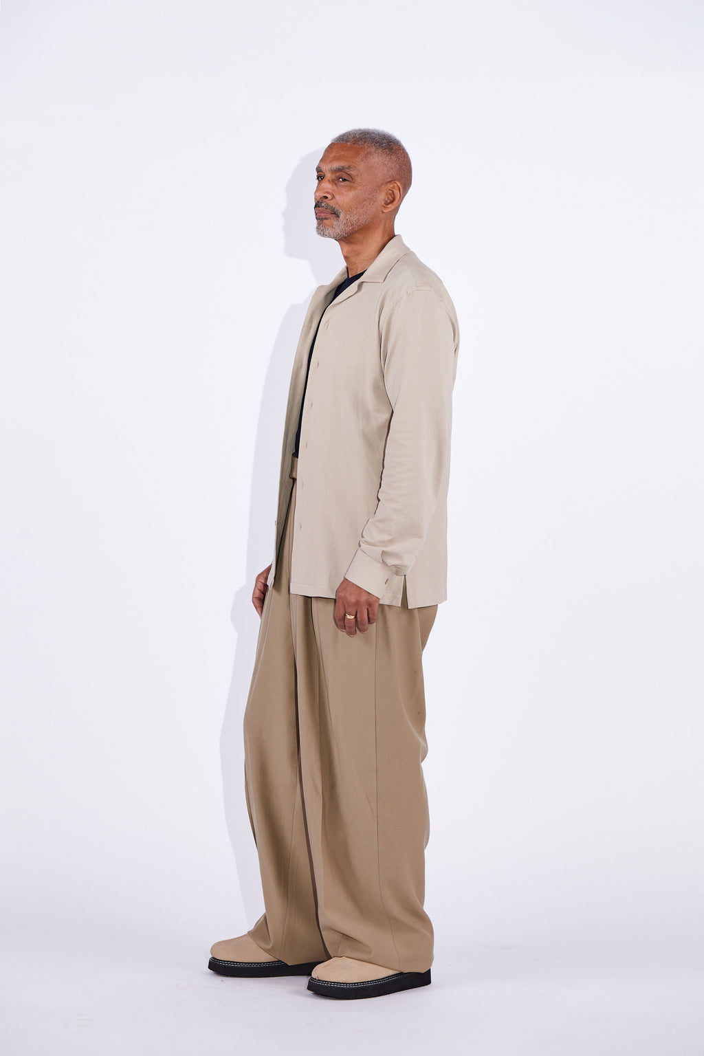 Model wears Casely-Hayford Jax shirt in beige. 