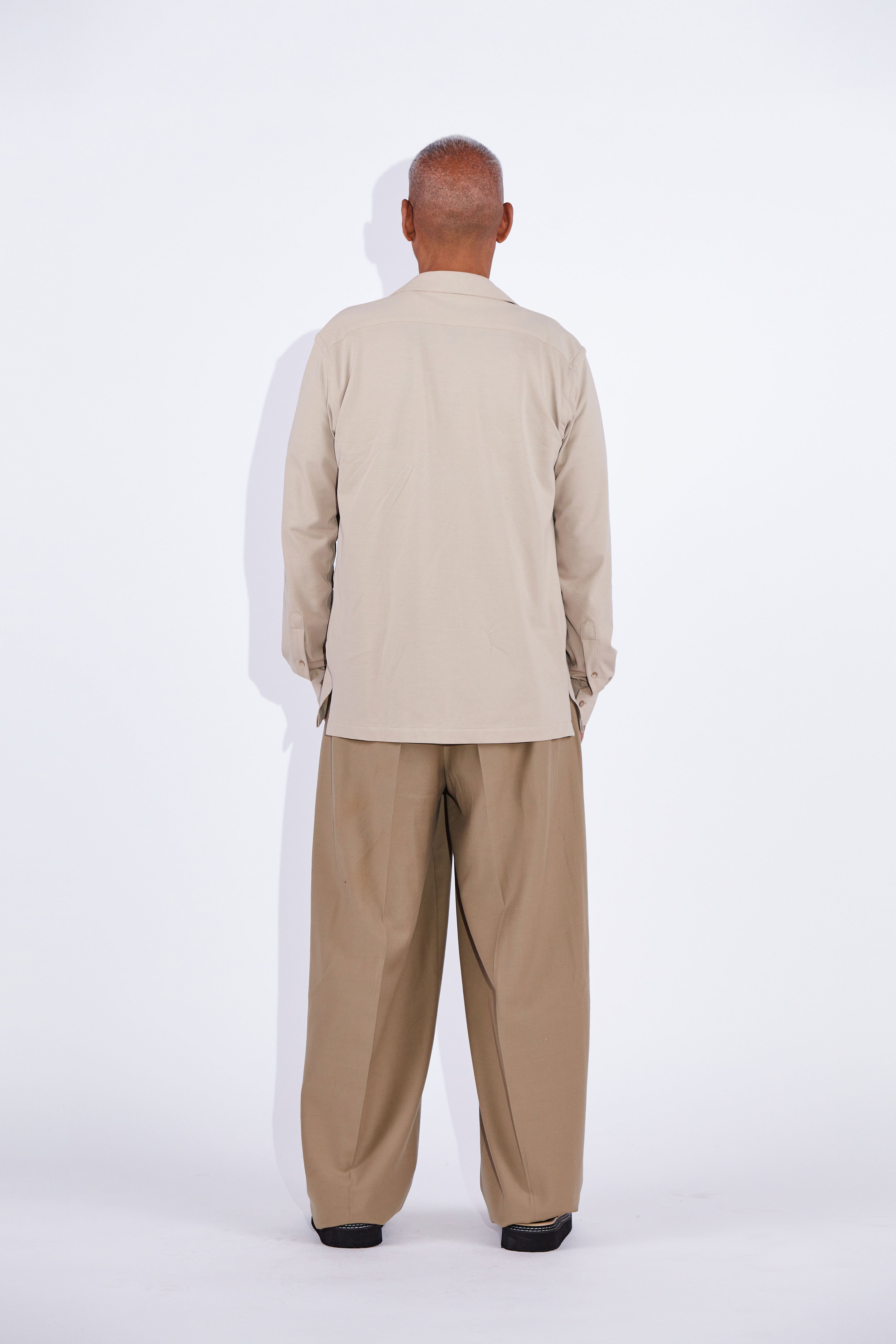 Model wears Casely-Hayford Jax shirt in beige. 