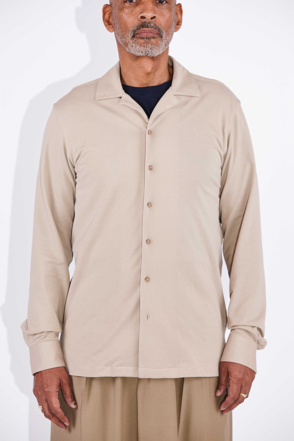 Model wears Casely-Hayford Jax shirt in beige. 