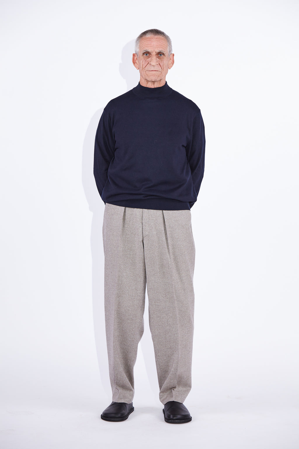 Model wears Casely-Hayford Stratis Navy High Crew Neck Knit Jumper. 