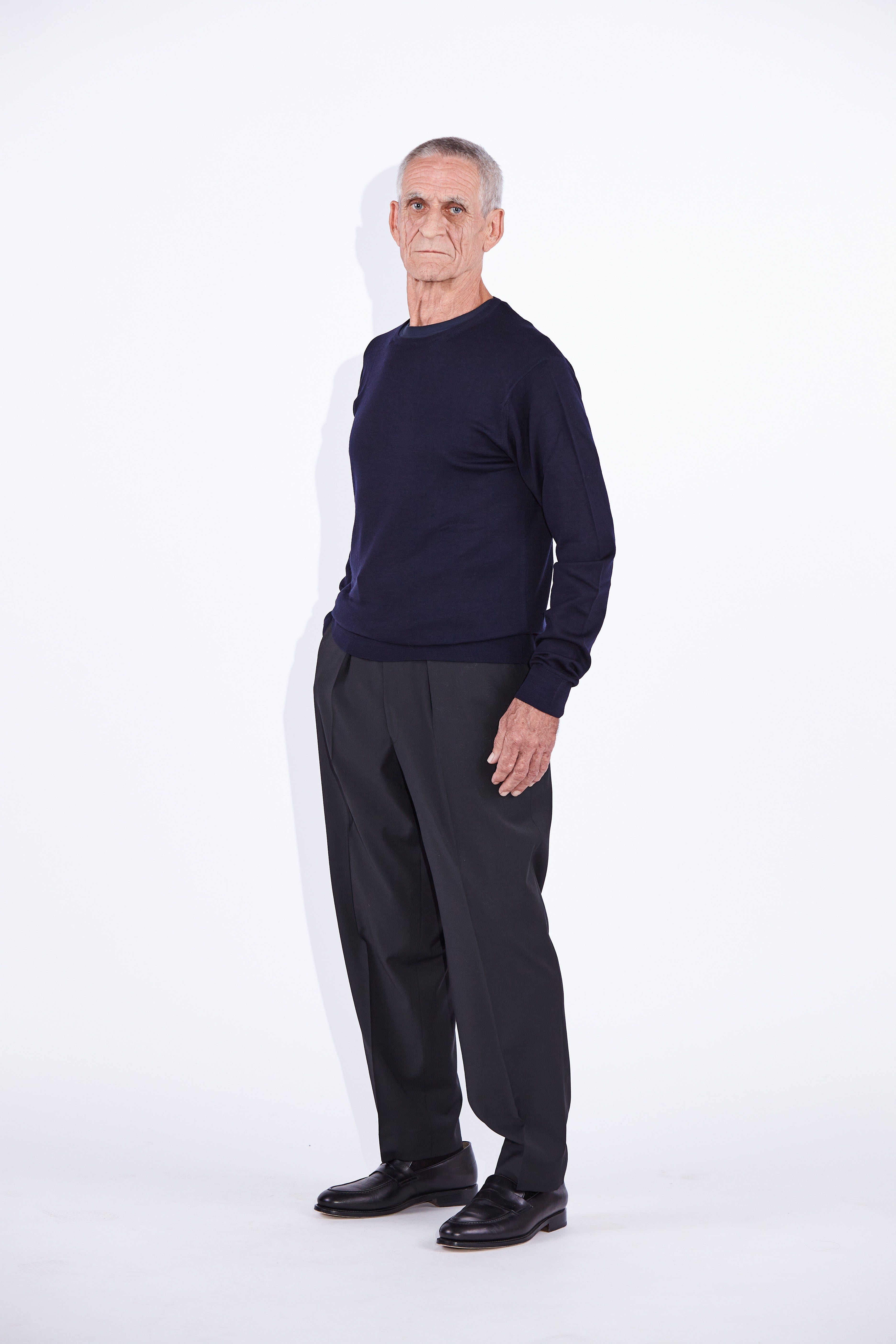 Model wears Casely-Hayford Augustin Navy Merino Wool Crew Neck Jumper. 