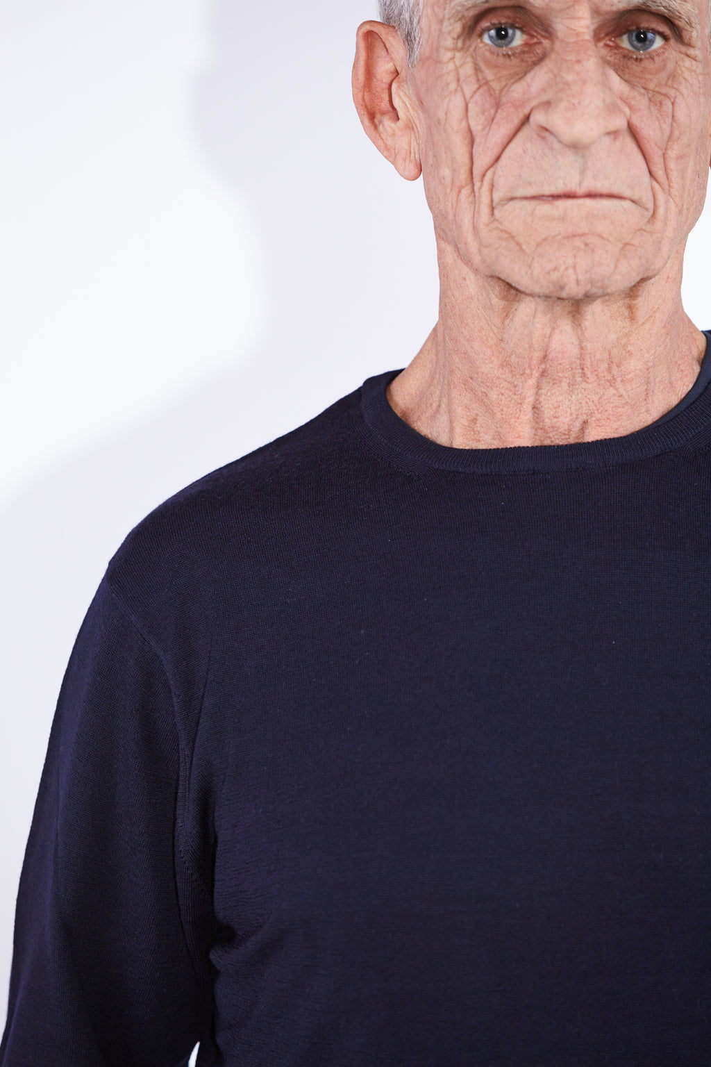 Model wears Casely-Hayford Augustin Navy Merino Wool Crew Neck Jumper. 