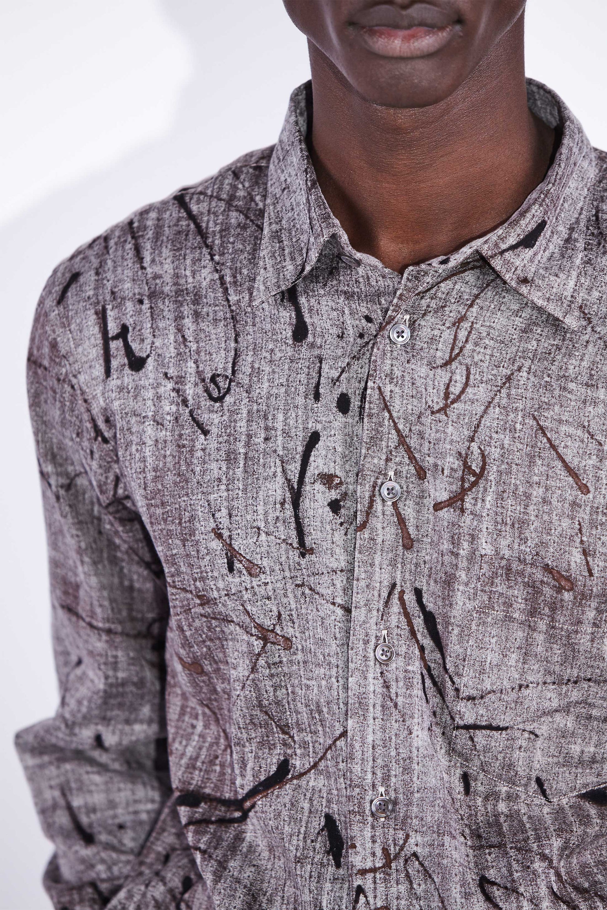 A brown patterned shirt with an organic  print worn by a black man