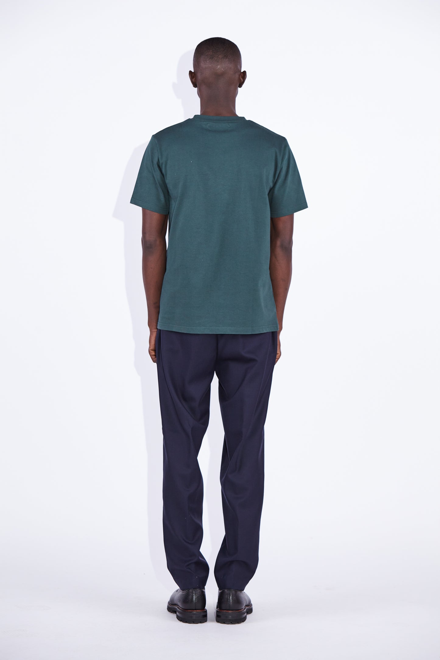 Casely Hayford Dejan Verde Relaxed Cotton T-shirt: Model is wearing a dark green deep neck trim, high crewneck t-shirt. Back view