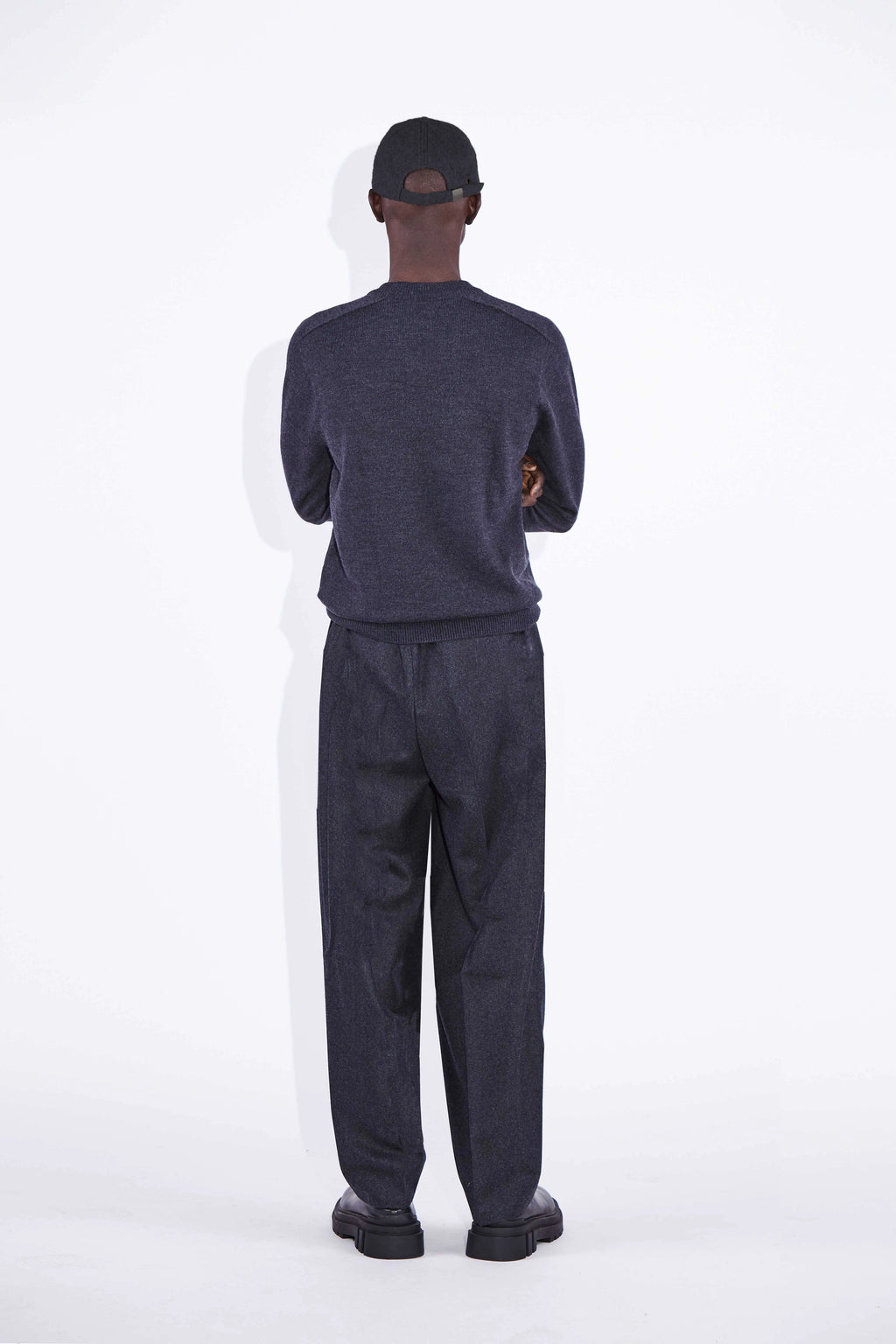 Model wears Casely-Hayford Nicolai Charcoal Merino Wool Knit. 