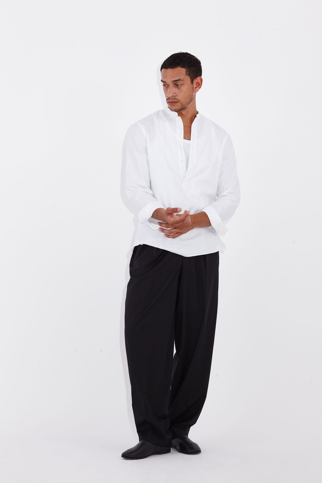 Model wears Casely-Hayford Tyler White Collarless Cotton Shirt. 
