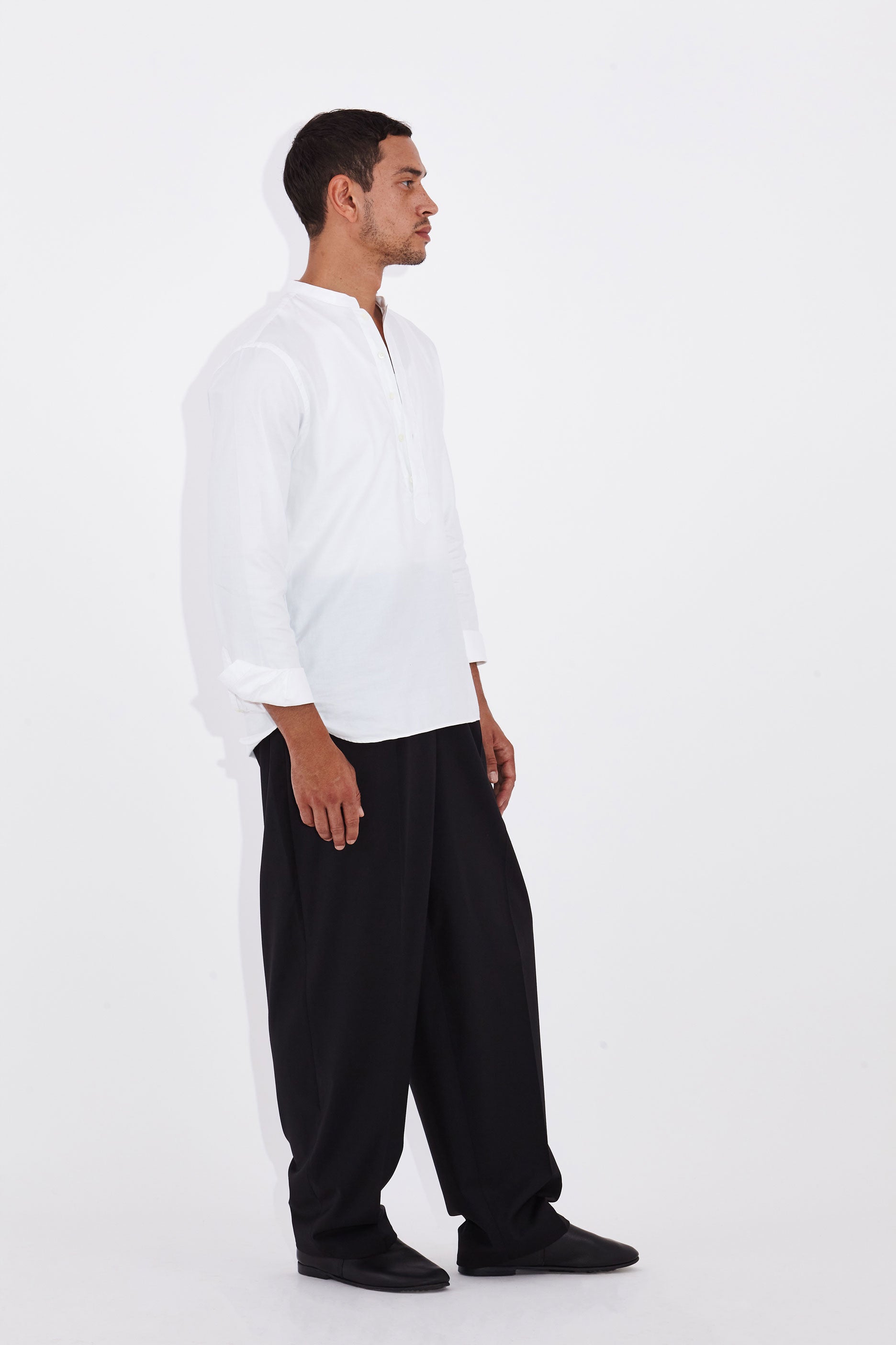 Model wears Casely-Hayford Tyler White Collarless Cotton Shirt. 