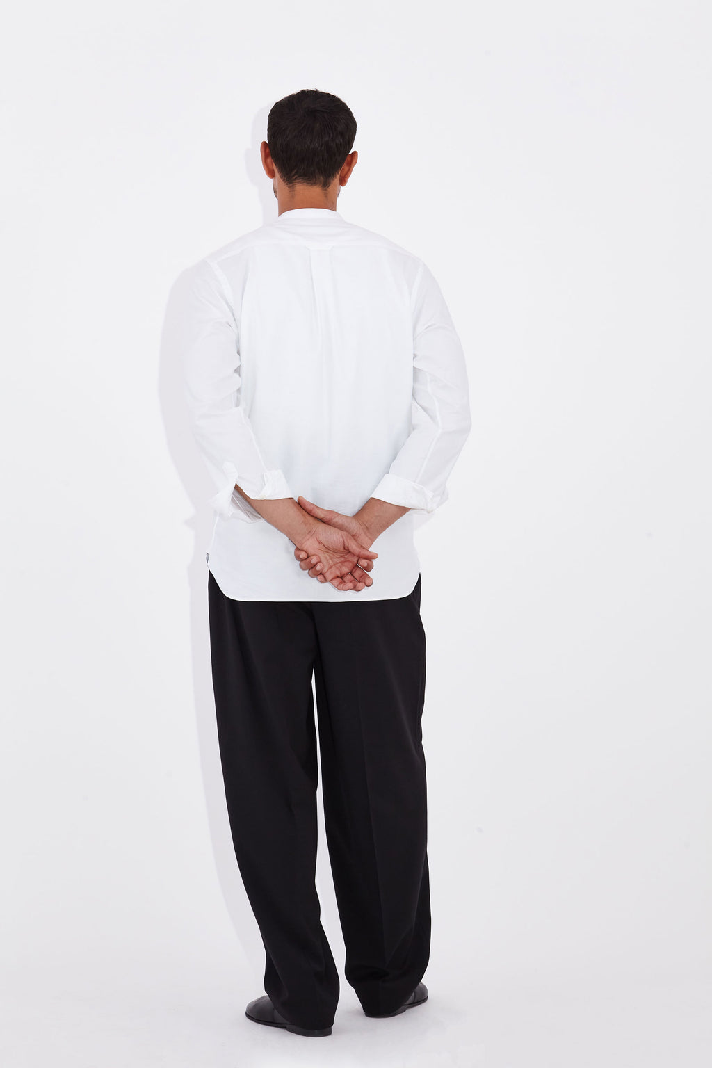 Model wears Casely-Hayford Tyler White Collarless Cotton Shirt. 