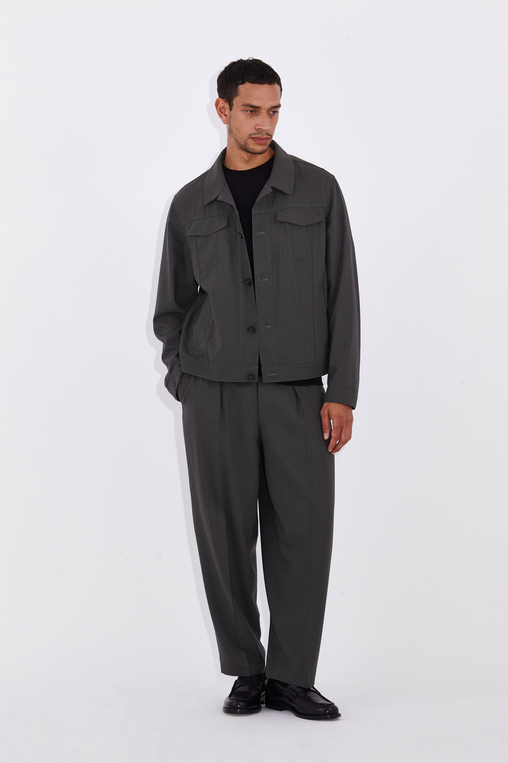 Model wears Casely-Hayford Axel Misty Olive Trucker Jacket. 