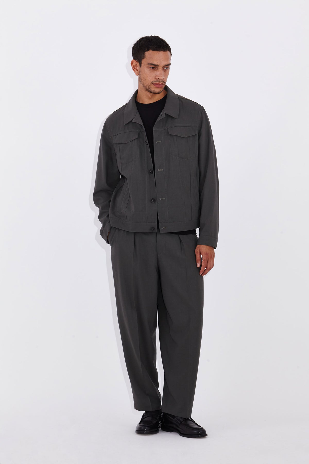 Model wears Casely-Hayford Axel Misty Olive Trucker Jacket. 