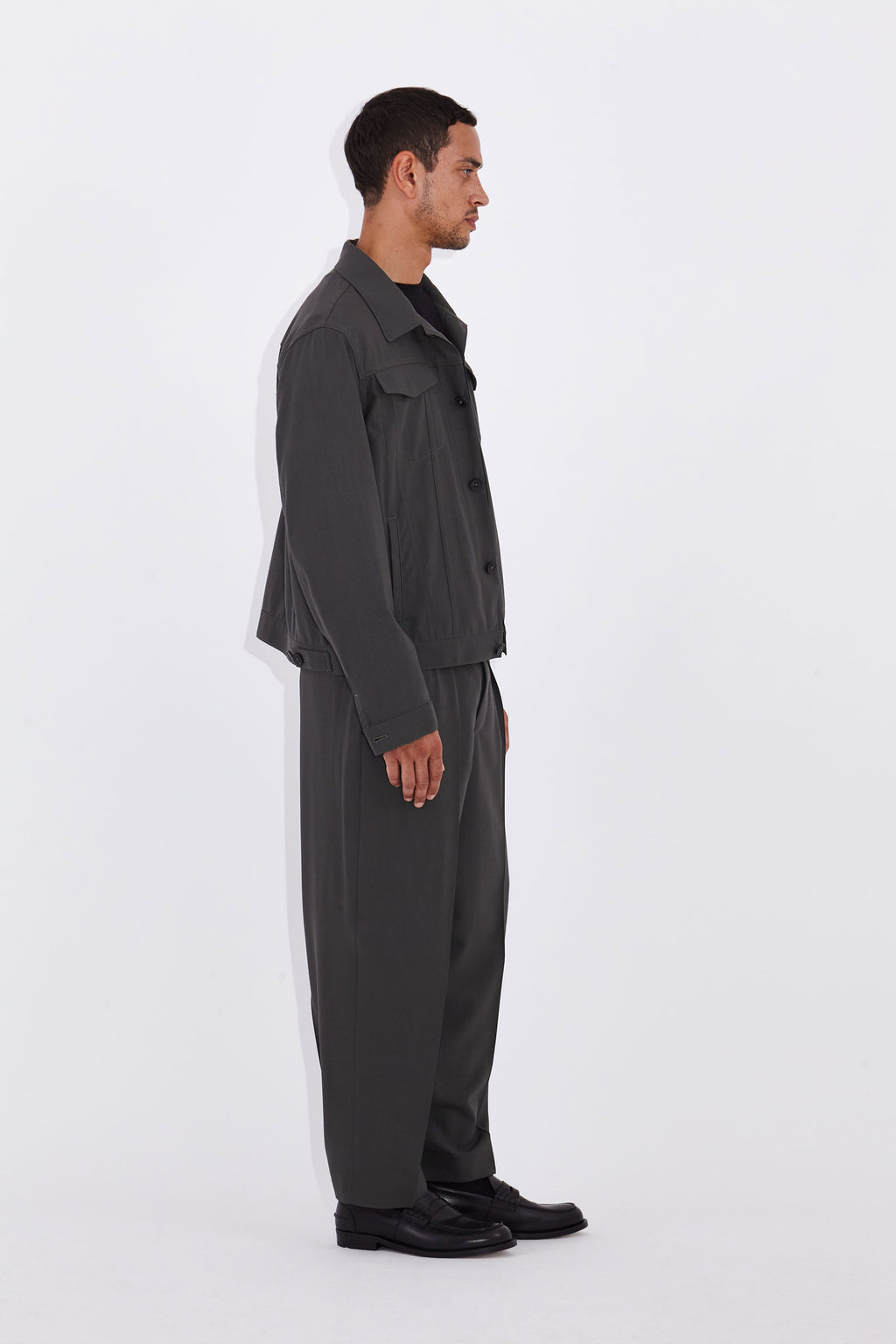 Model wears Casely-Hayford Axel Misty Olive Trucker Jacket. 
