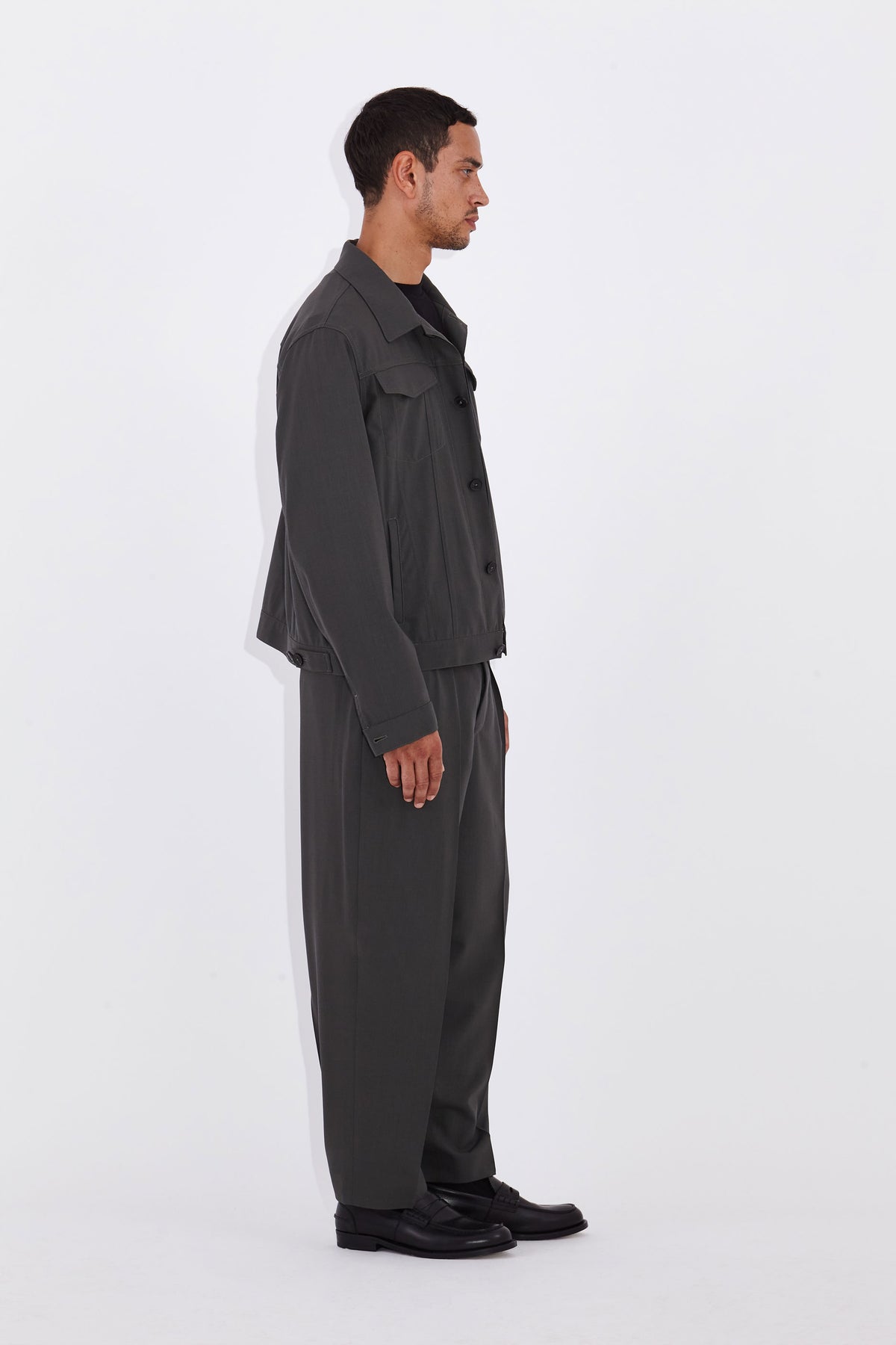 Model wears Casely-Hayford Axel Misty Olive Trucker Jacket. 