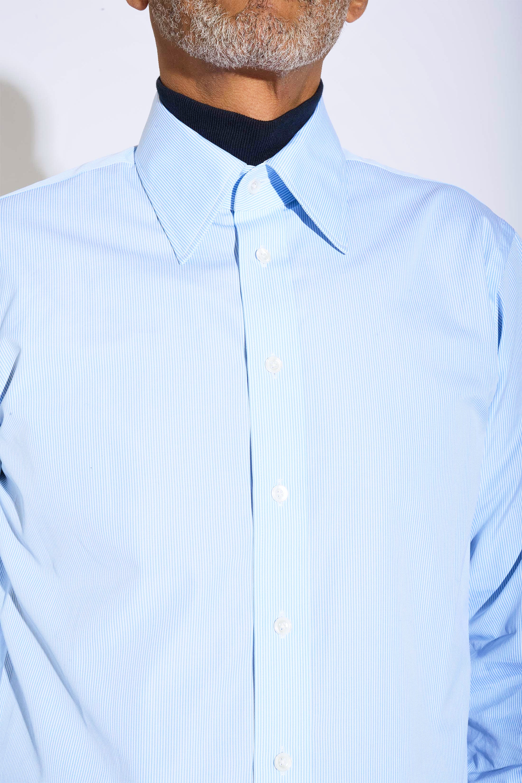 Model wears Casely-Hayford Duval Blue Stripe Long Point Collar Cotton Shirt. 