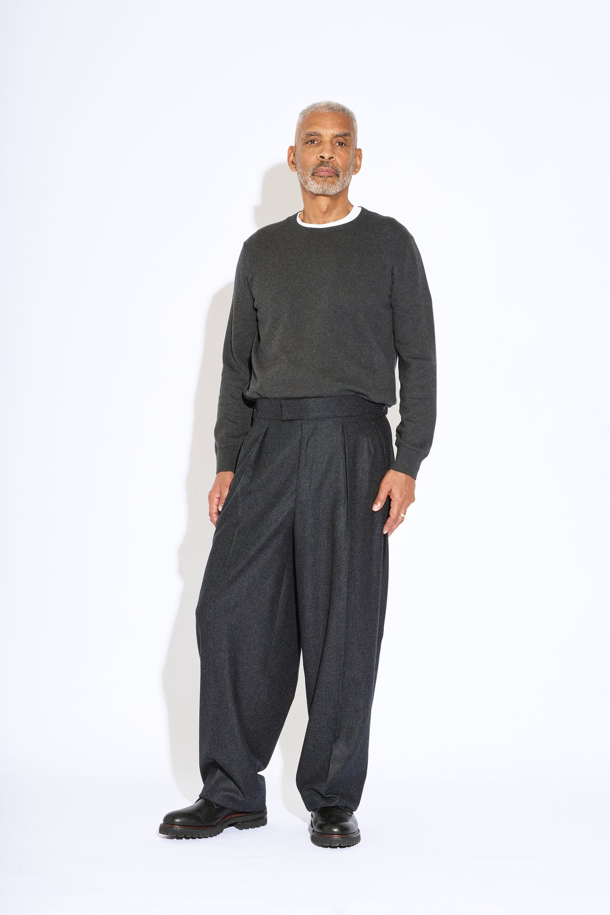 Model wears Casely-Hayford Hannes Charcoal Wide Legged Wool Trousers. 