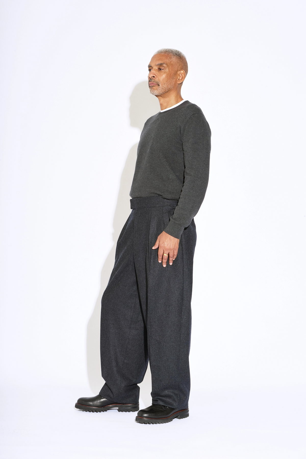 Model wears Casely-Hayford Hannes Charcoal Wide Legged Wool Trousers. 