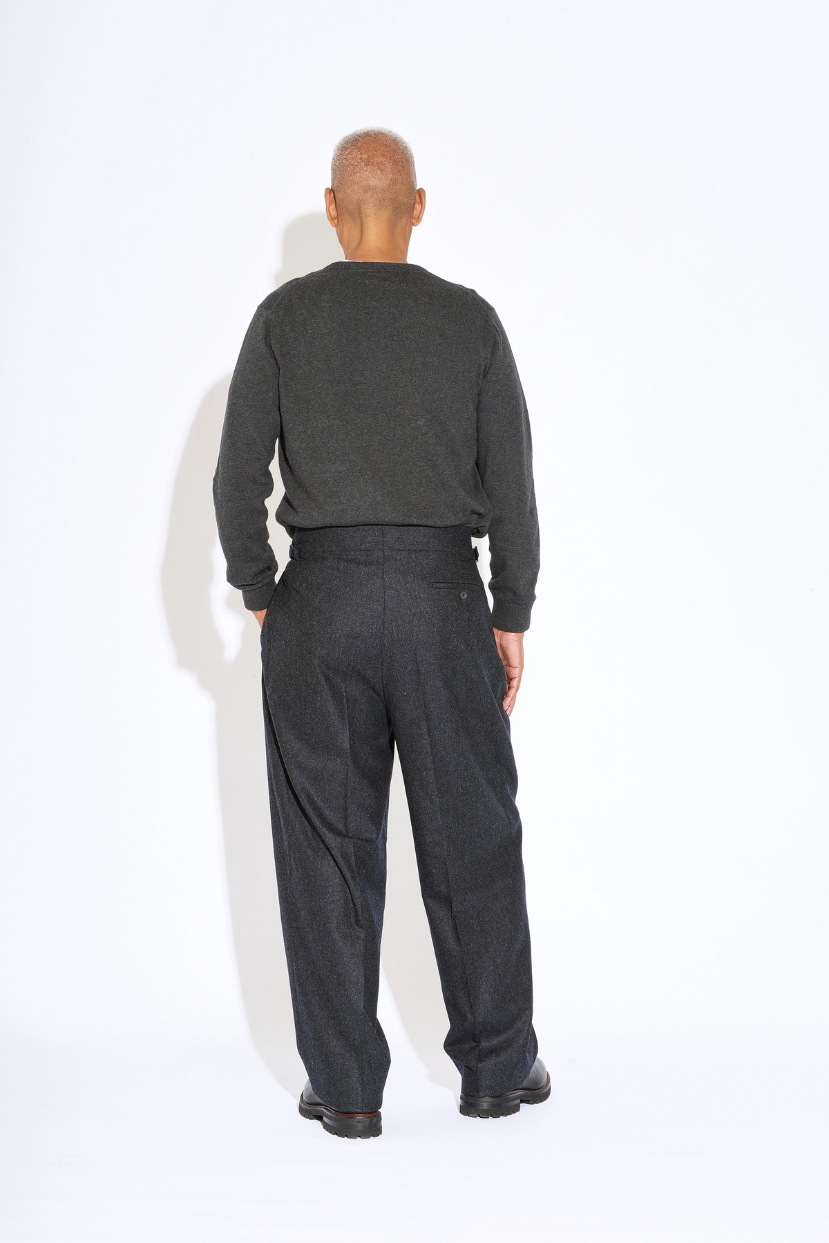 Model wears Casely-Hayford Hannes Charcoal Wide Legged Wool Trousers. 