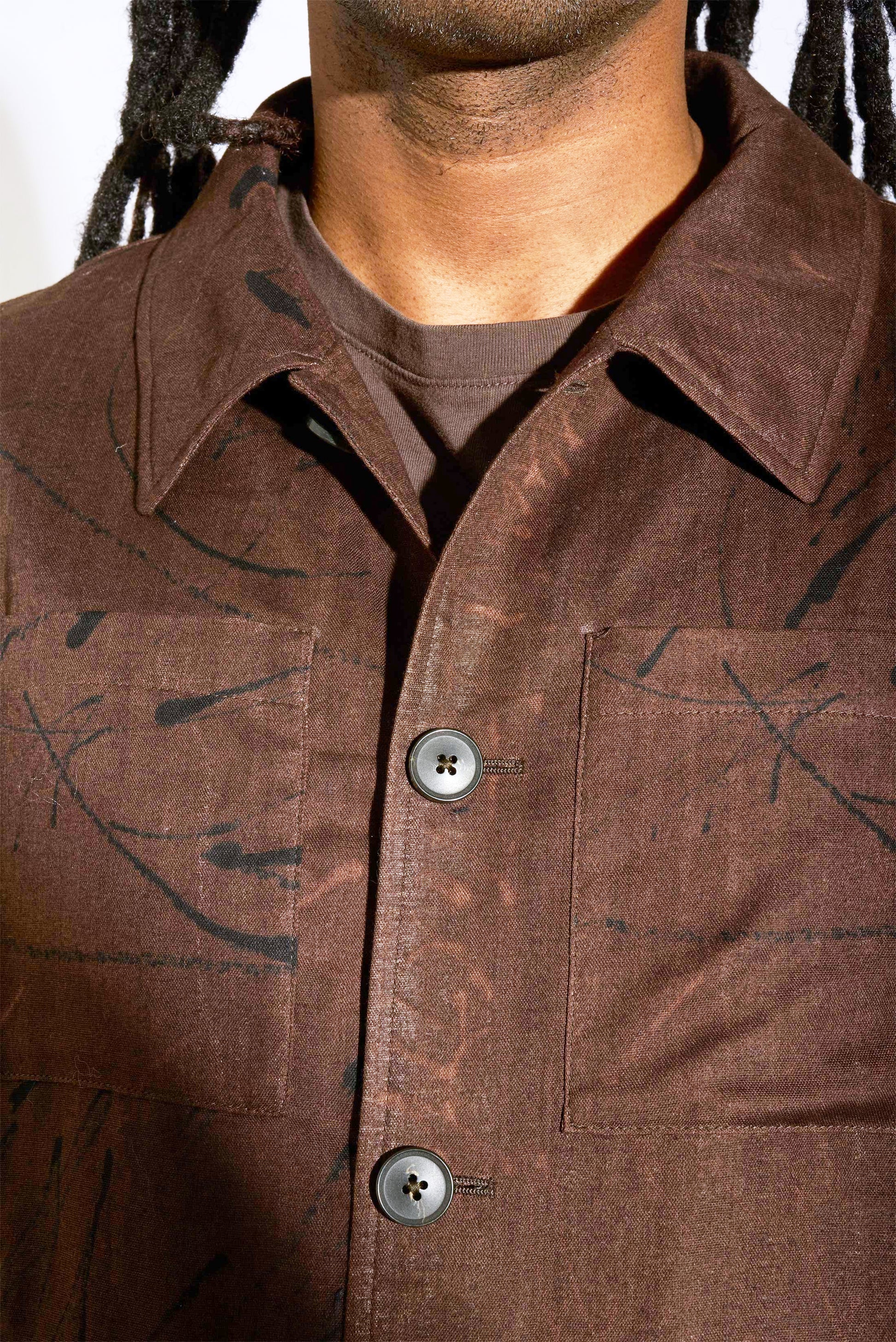 close up of man's torso in brown printed bomber jacket