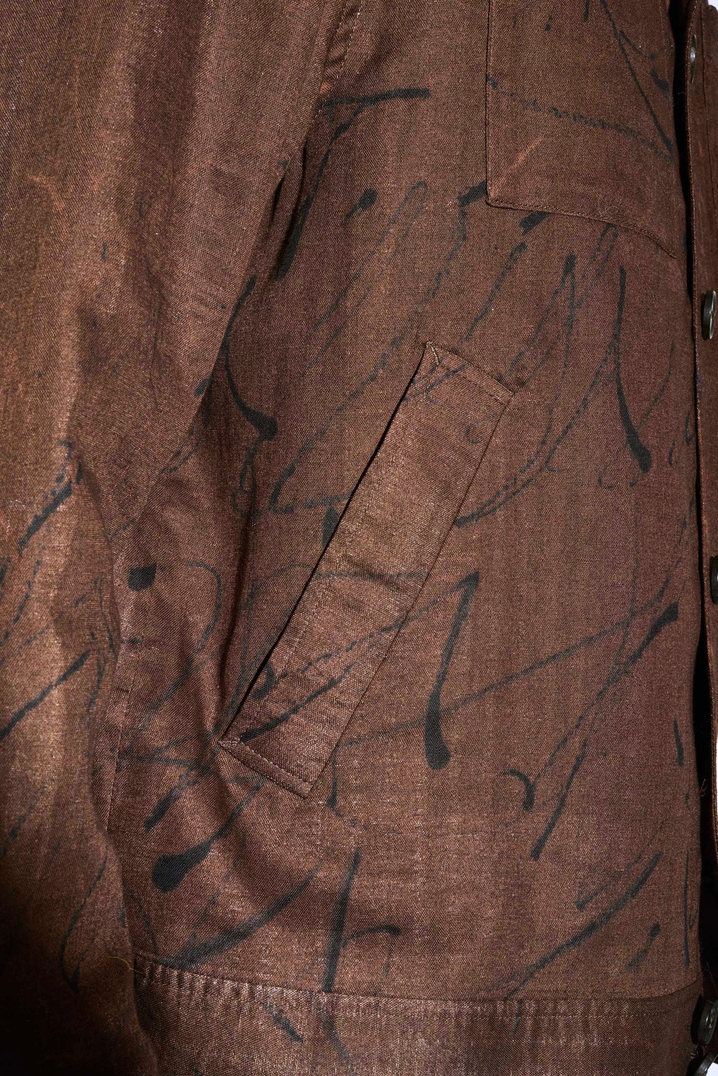 close up detail image of man's welt pocket on a brown printed bomber jacket