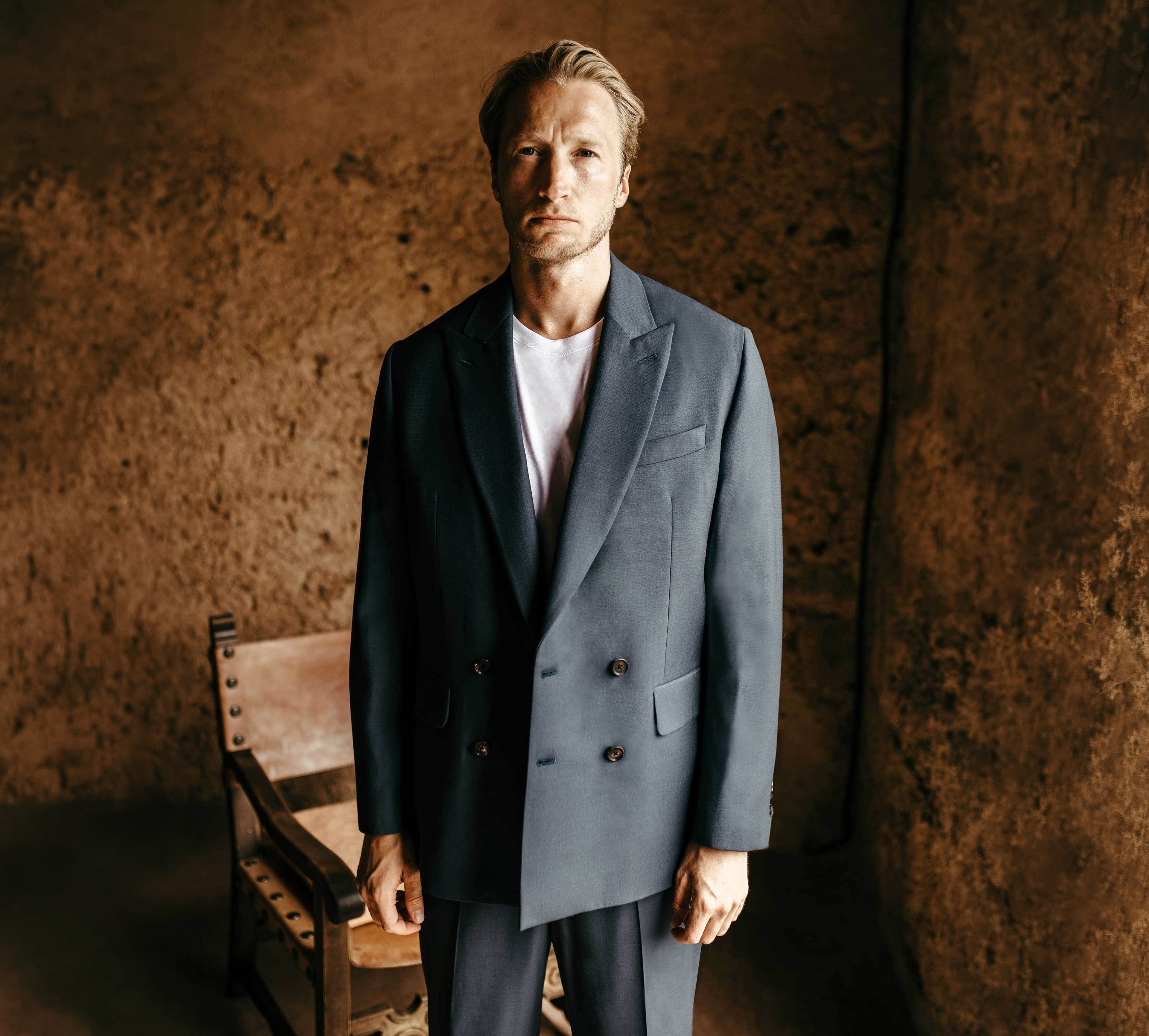 Model wears Casely-Hayford relaxed suit in navy paired with white t-shirt.