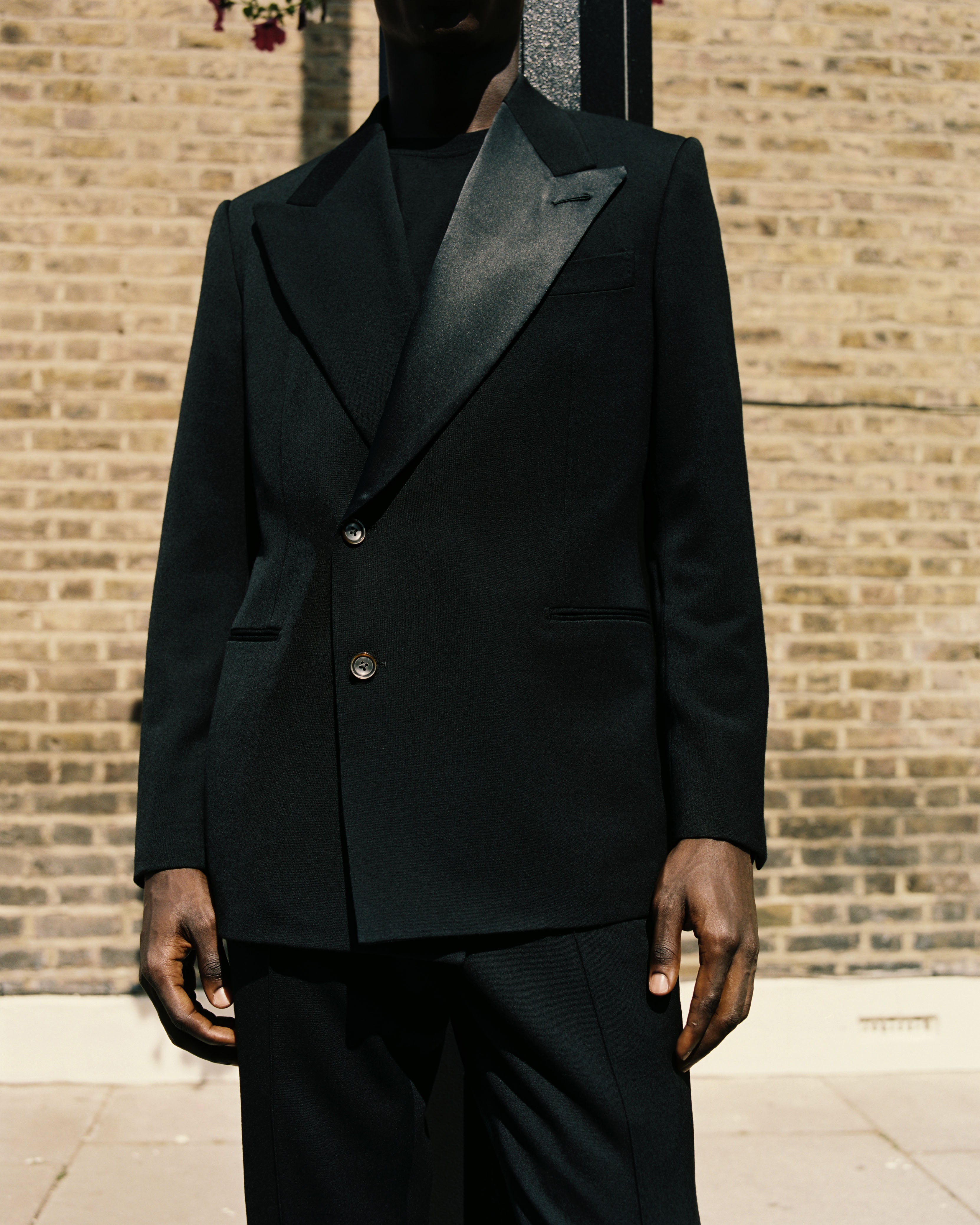 Model wears Casely-Hayford made to measure suit in black. 