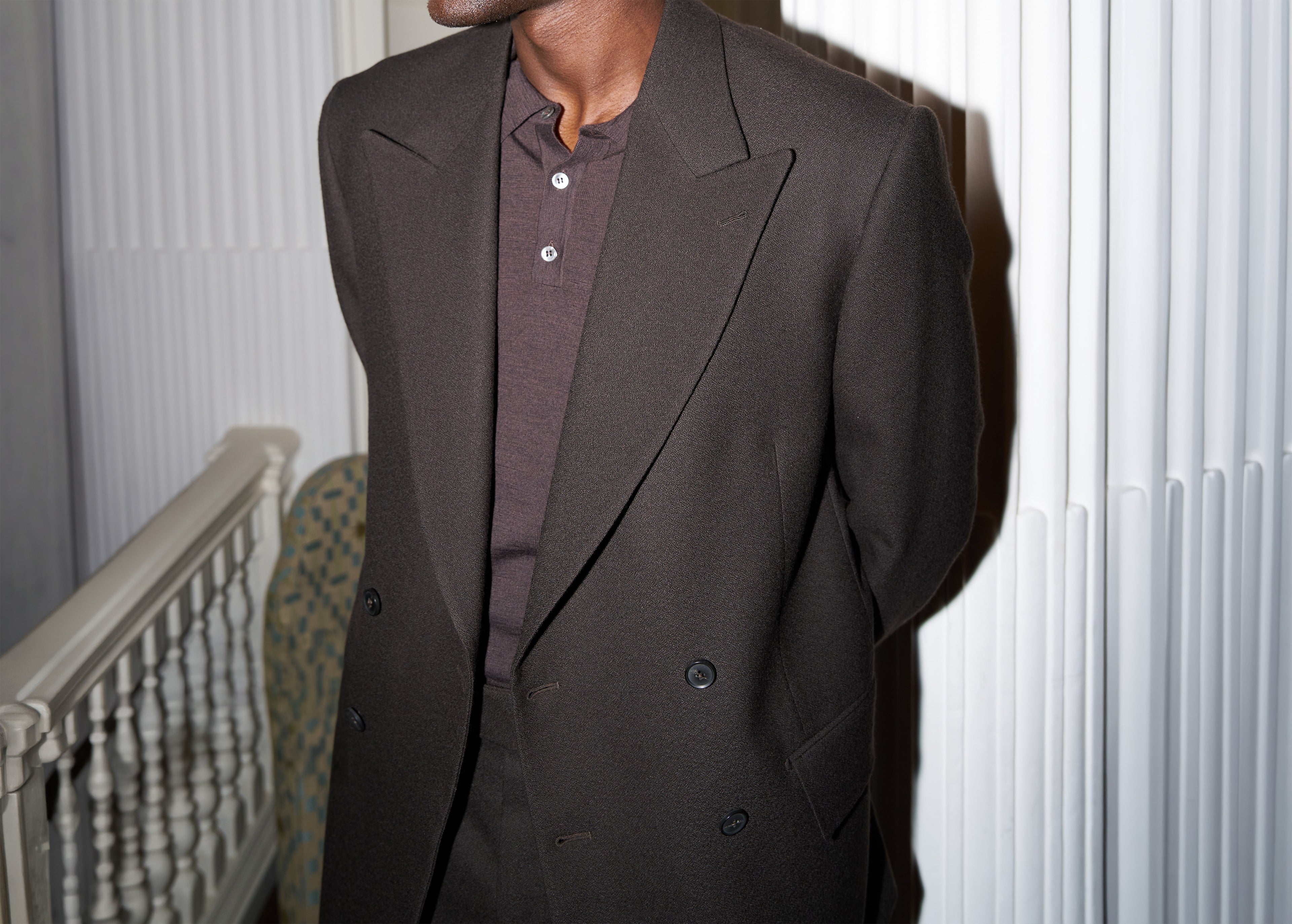 Model wears Casely-Hayford Hector suit in brown, paired with brown knit. 