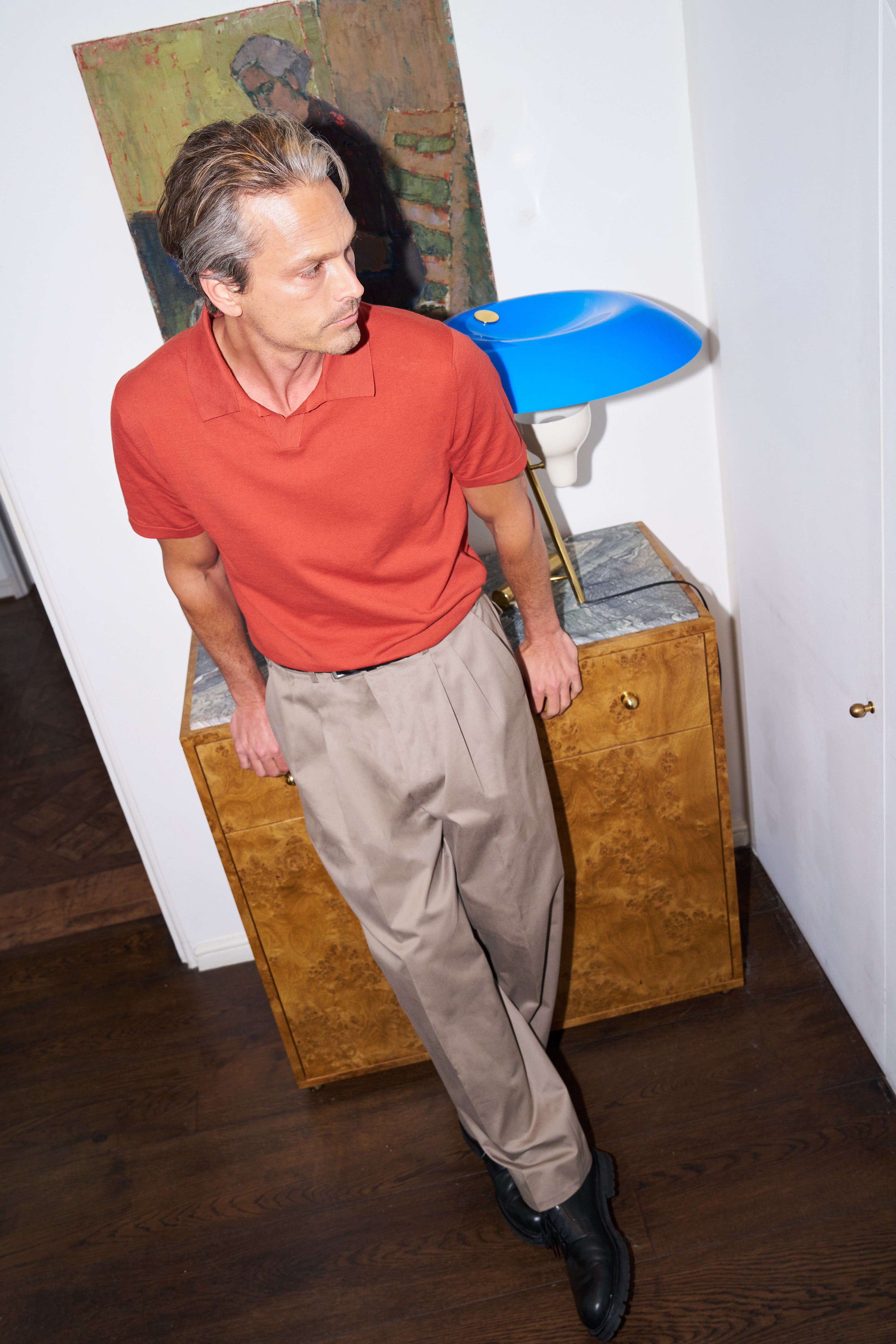 Model wears the Casely-Hayford Dami knit in orange and the Ruben tailored trouser in beige.