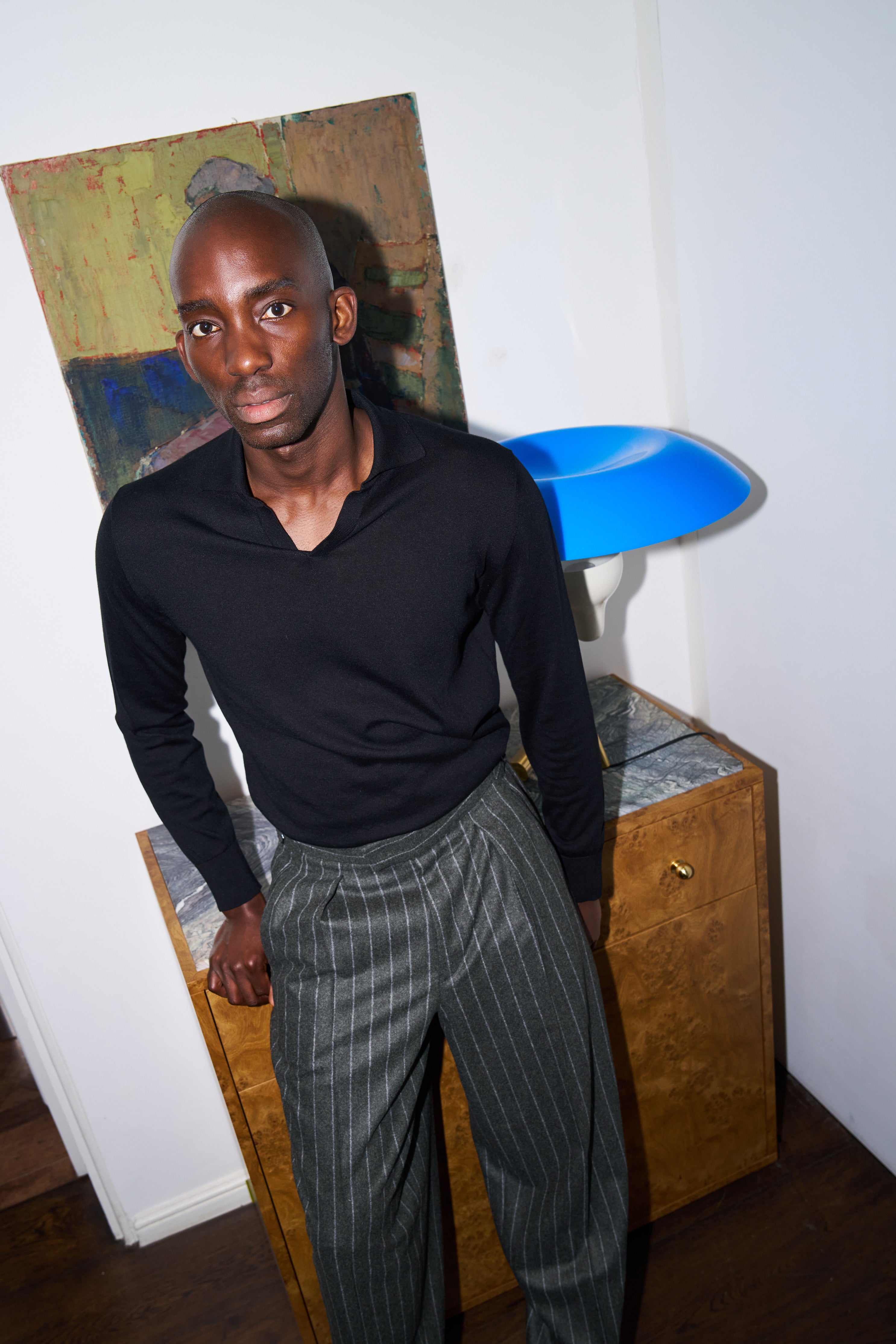 Model wears the Casely-Hayford Hannes trousers in chalk stripe, paired with the Caleb knit in a relaxed silhouette.