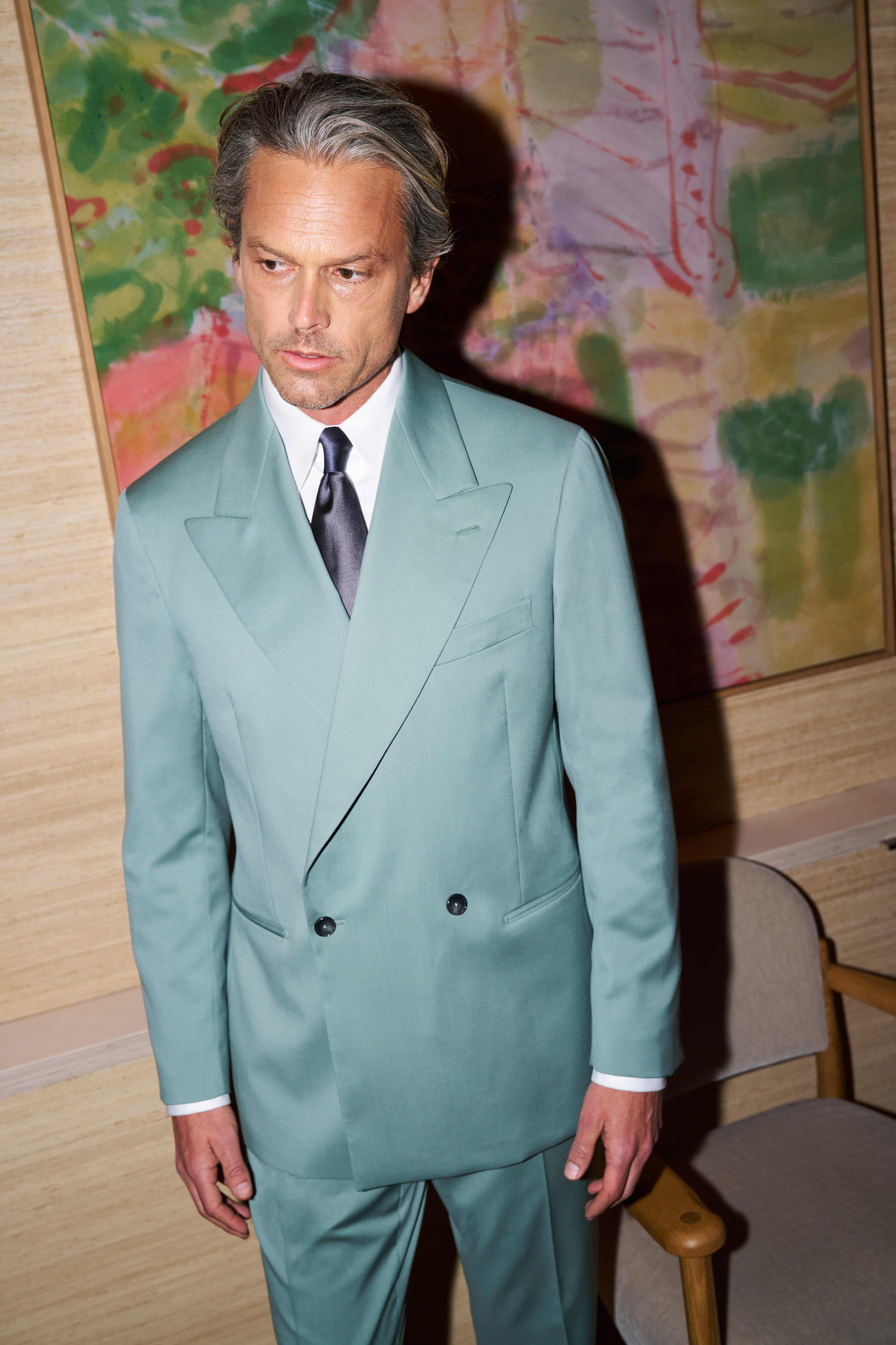 Model wears the Casely-Hayford Lakin suit in teal, paired with a silk Italian tie. 