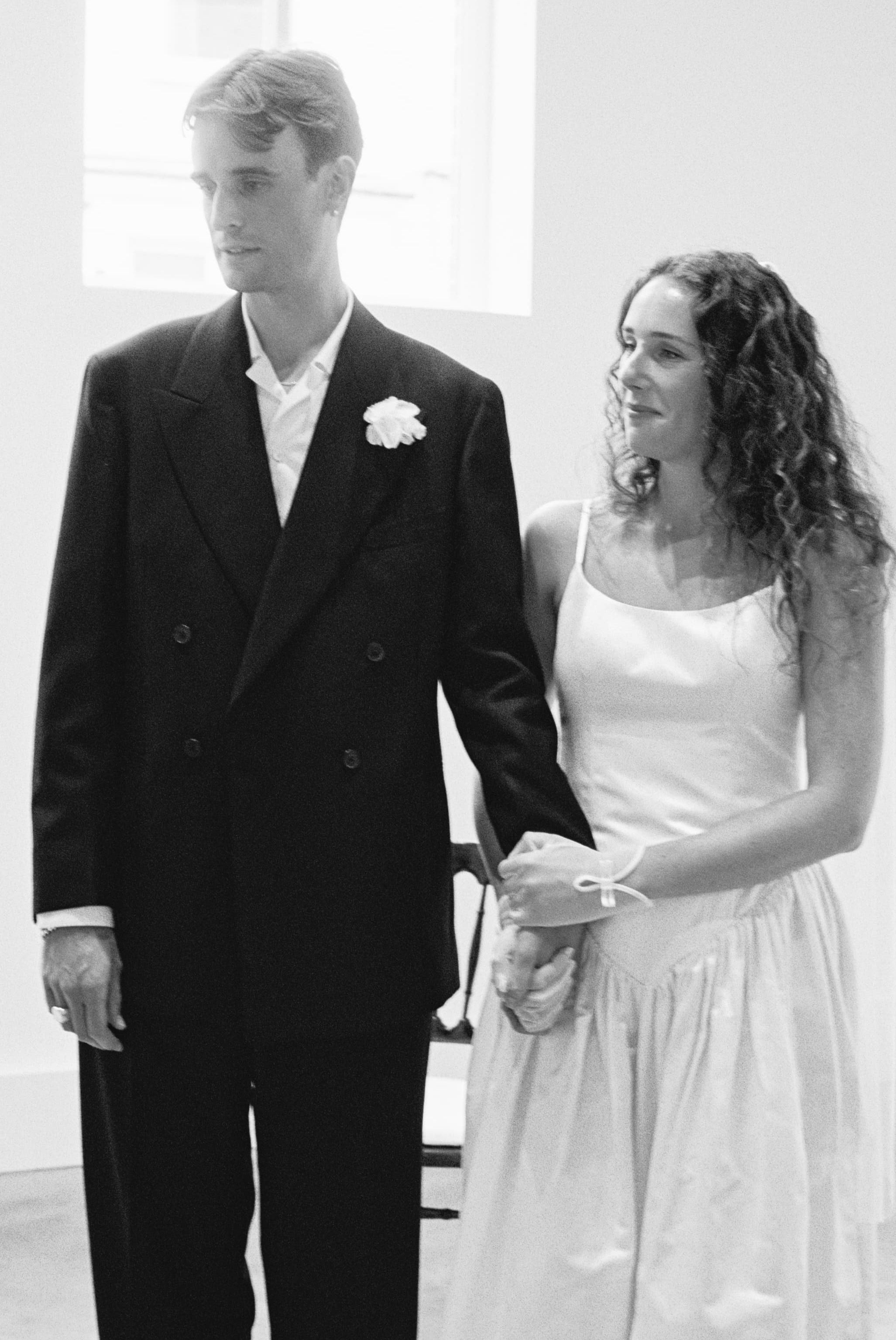 Groom wears Casely-Hayford relaxed tailoring suit in black, black and white image.