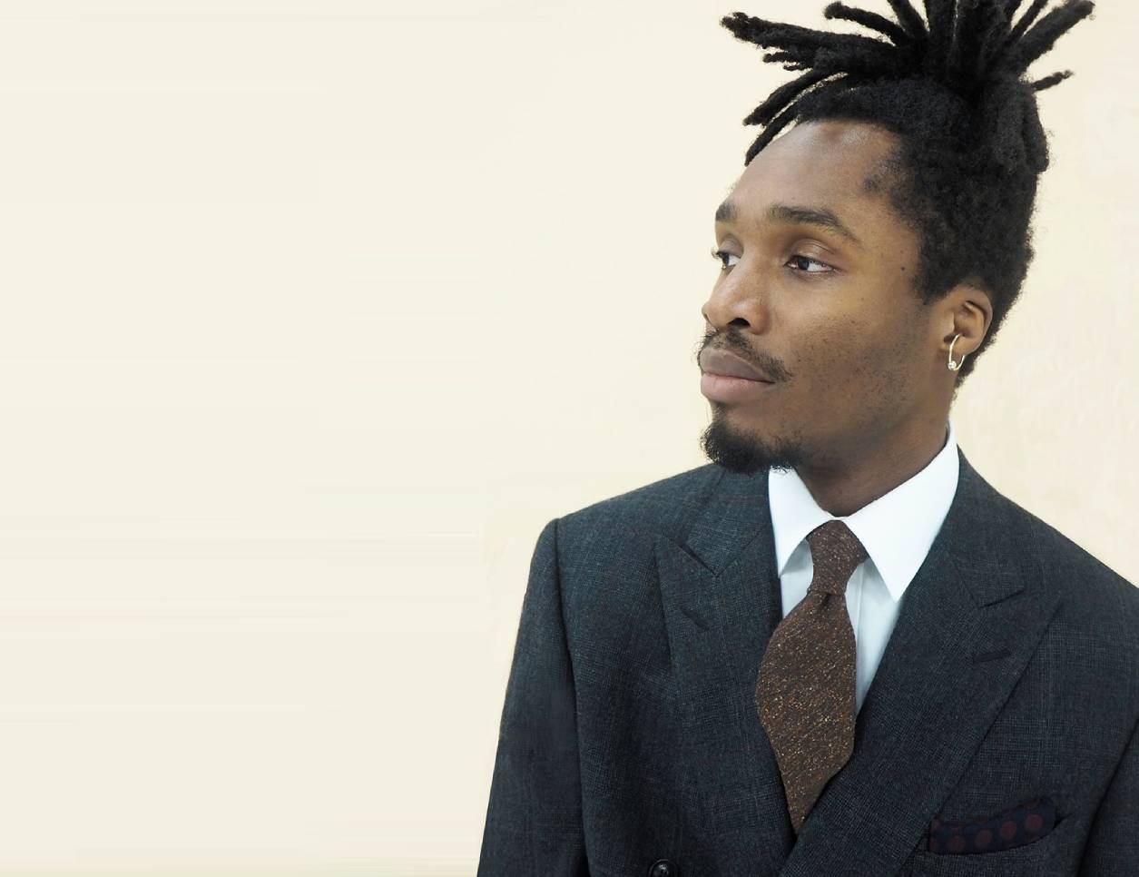 Model wears Casely-Hayford tailored suit in grey. 