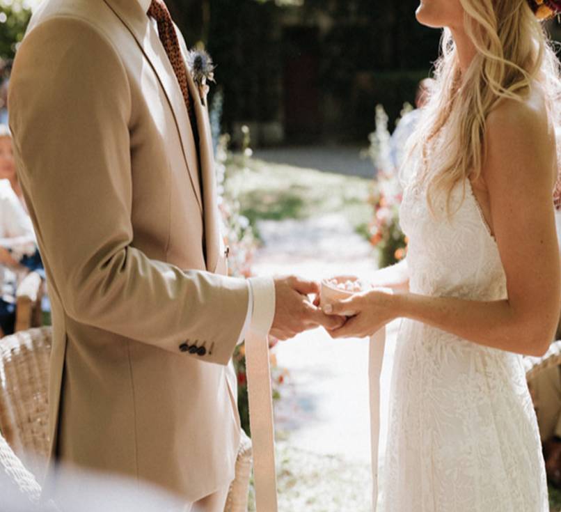 Groom wears made-to-measure wedding suit in cream. 