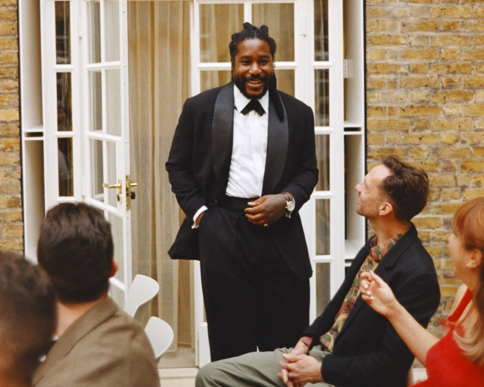 Groom wears Casely-Hayford relaxed evening suit in black. 