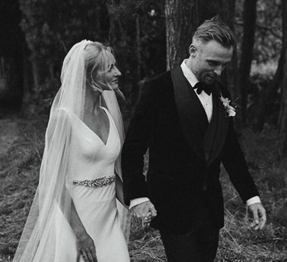 Bride and Groom walking in a forest. Groom wears made-to-measure Casely-Hayford Tuxedo.
