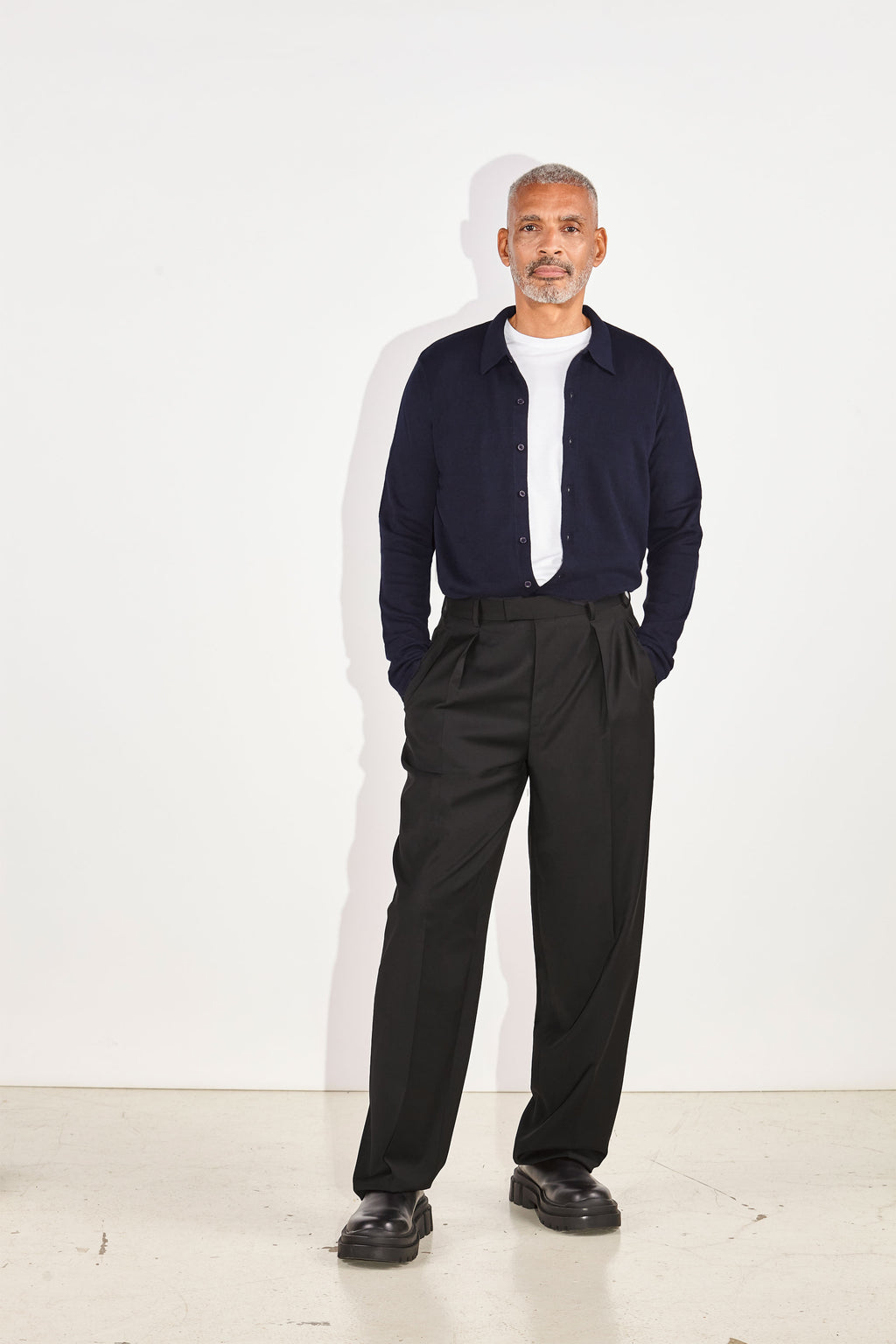 Model wears Casely-Hayford Aksel Navy Button Through Knitted Polo Cotton Shirt. 