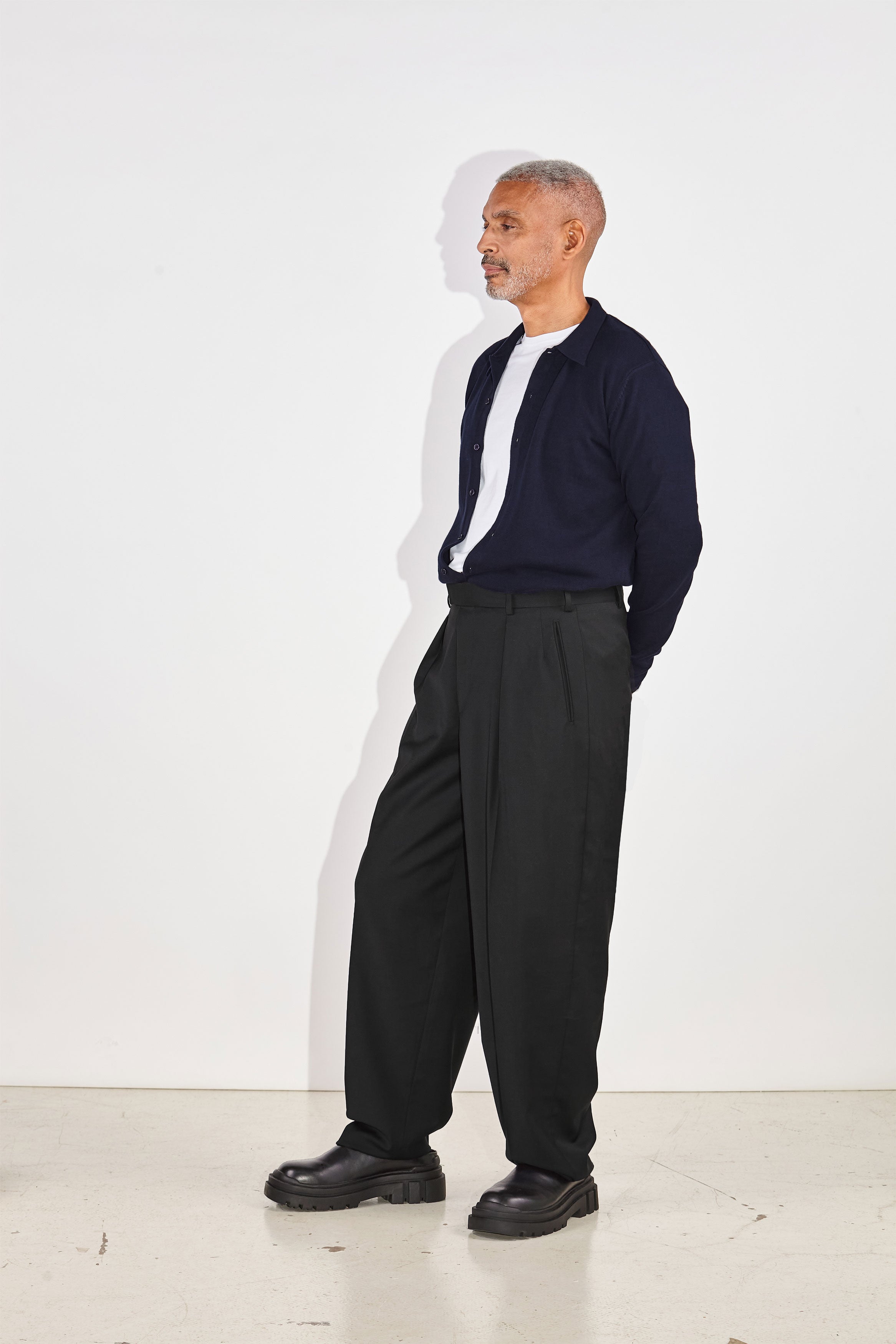 Model wears Casely-Hayford Aksel Navy Button Through Knitted Polo Cotton Shirt. 