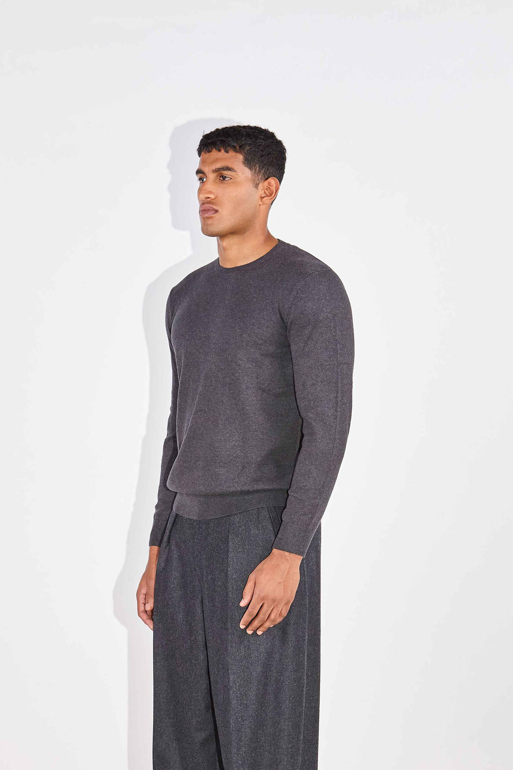 Model wears Casely-Hayford Augustin Charcoal Crew Neck Cotton Jumper.